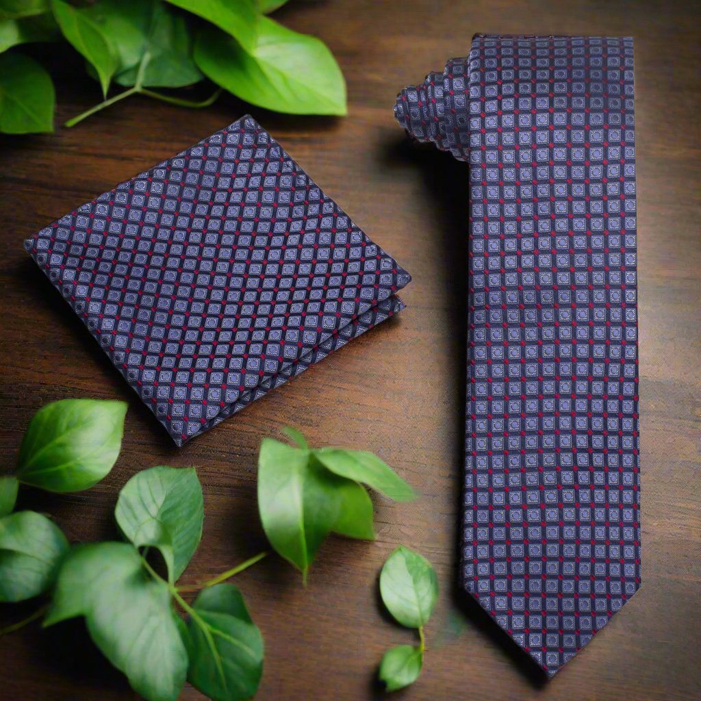 Silk geometric check necktie in blue and red laid out on a desk