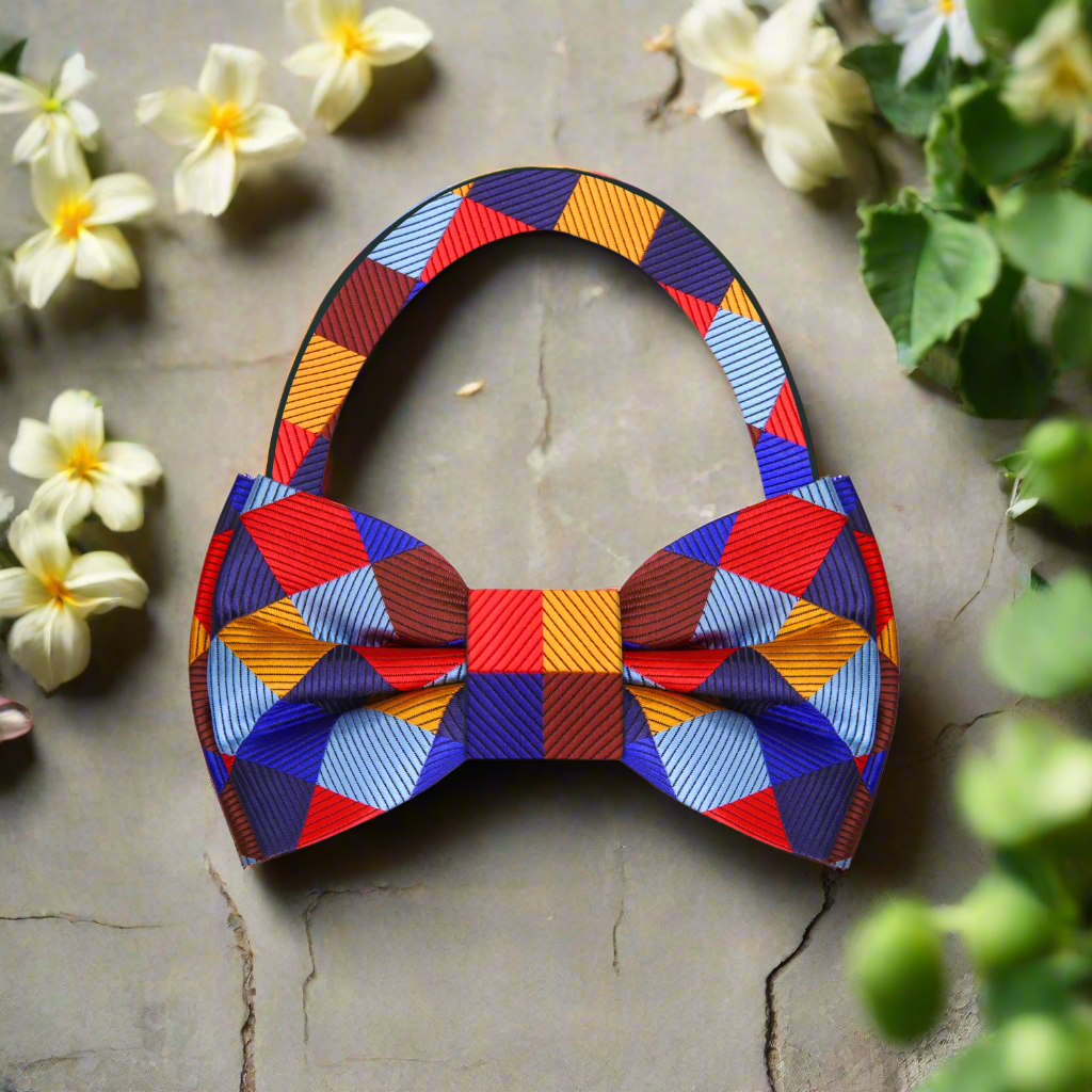 Styled shot of a silk plaid bow tie paired with a crisp white dress shirt