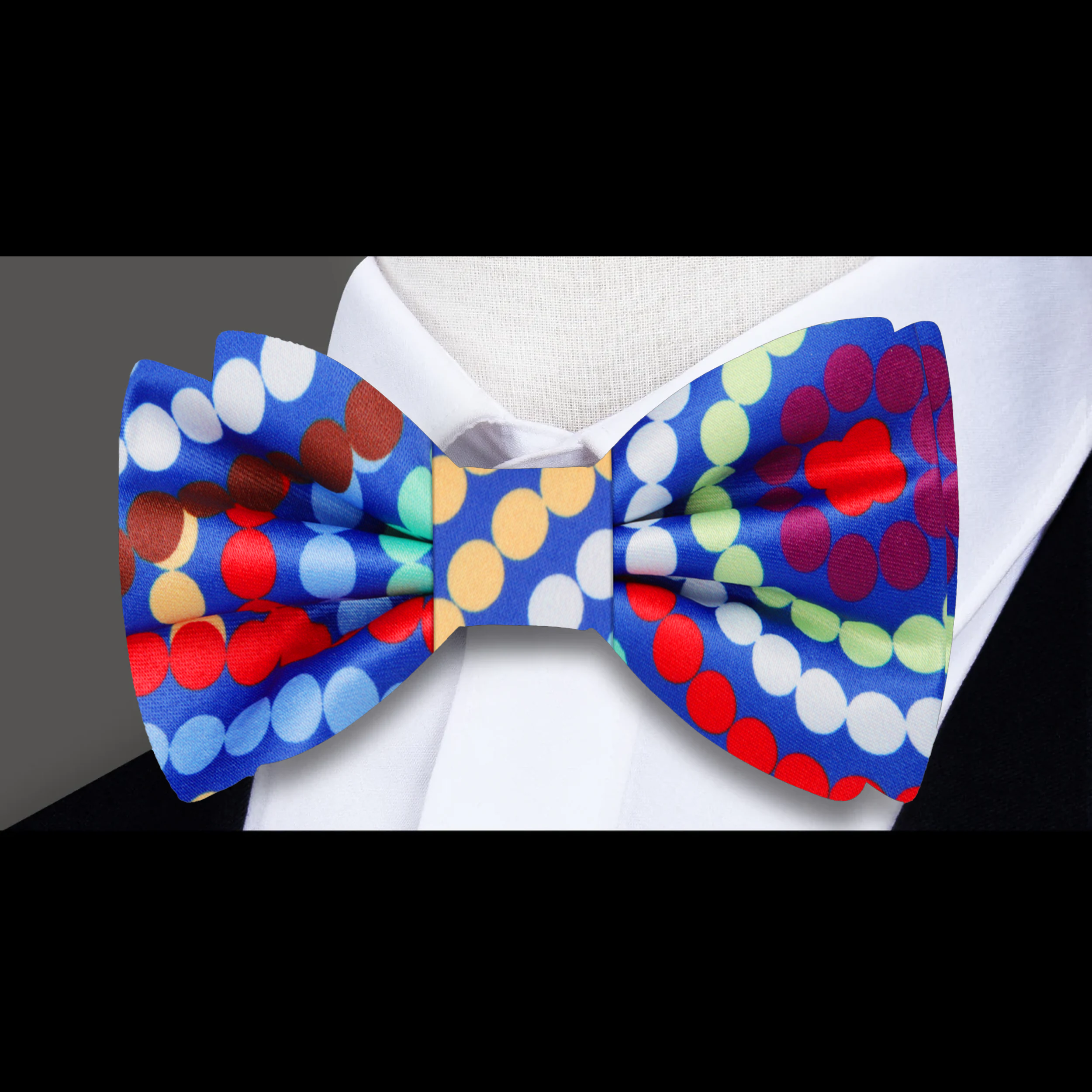 Model wearing the vibrant swirl polka dot bow tie at a cocktail party, demonstrating its classy appeal.