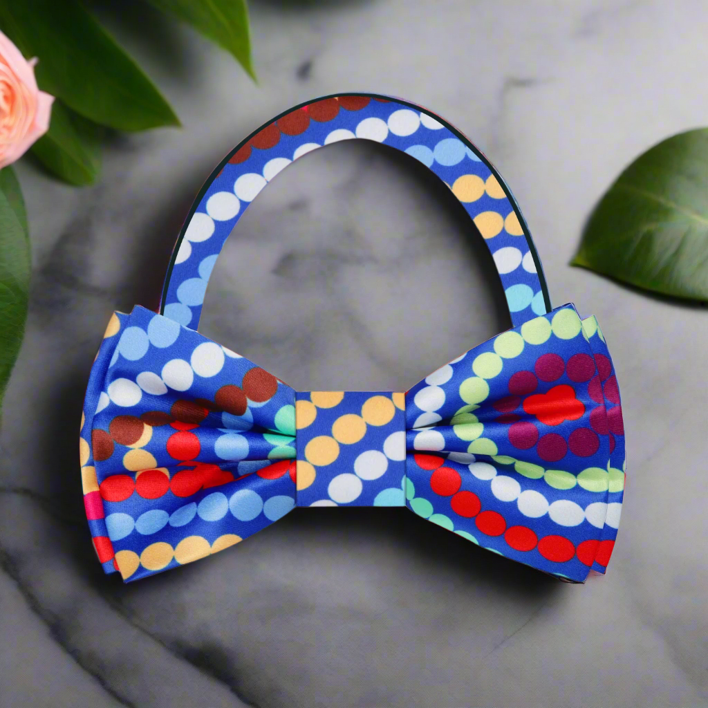 Close-up of the vibrant swirl polka dot bow tie against a navy suit, highlighting its playful pattern.