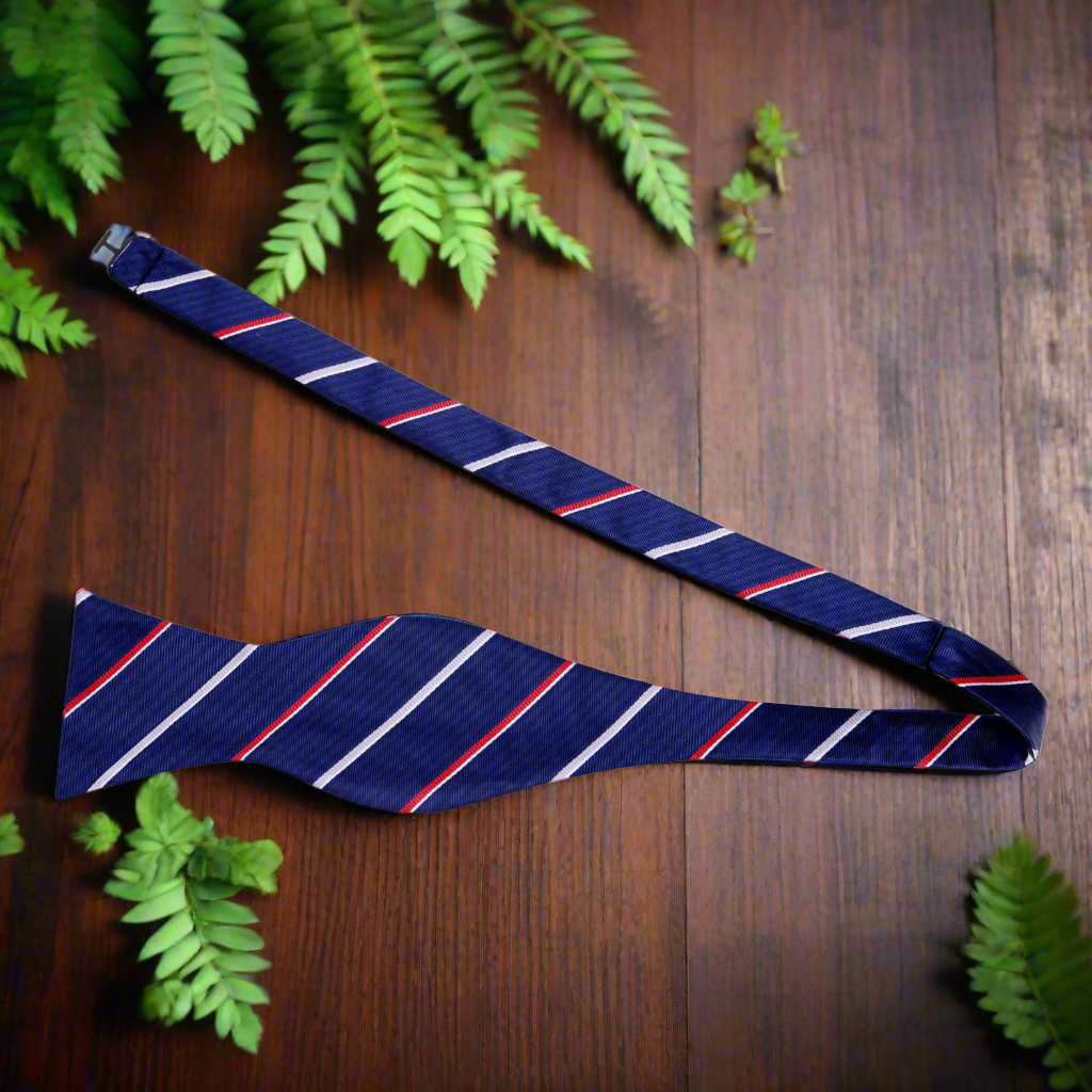 Close-up of grey and blue striped silk bow tie on a model, highlighting the pattern and fabric quality