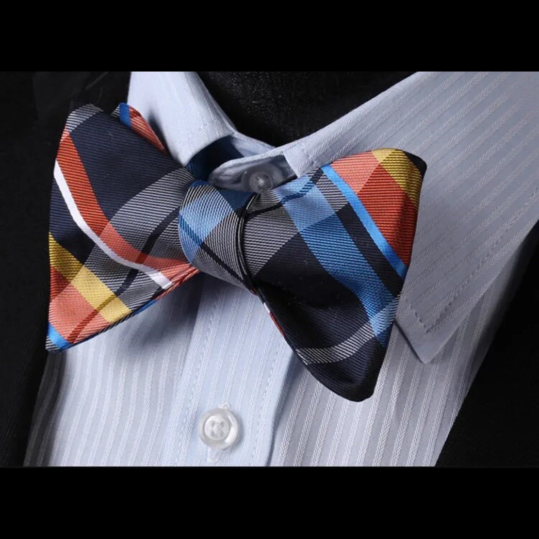 Model wearing a plaid bow tie for navy suit at a wedding reception
