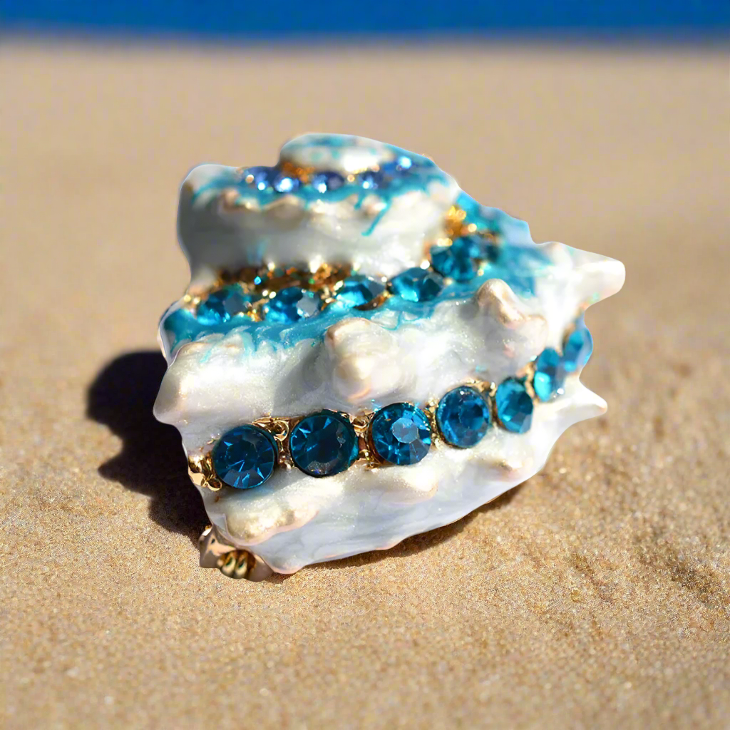 Stylish display of the conch shell pin against a coastal backdrop, emphasizing its oceanic inspiration.