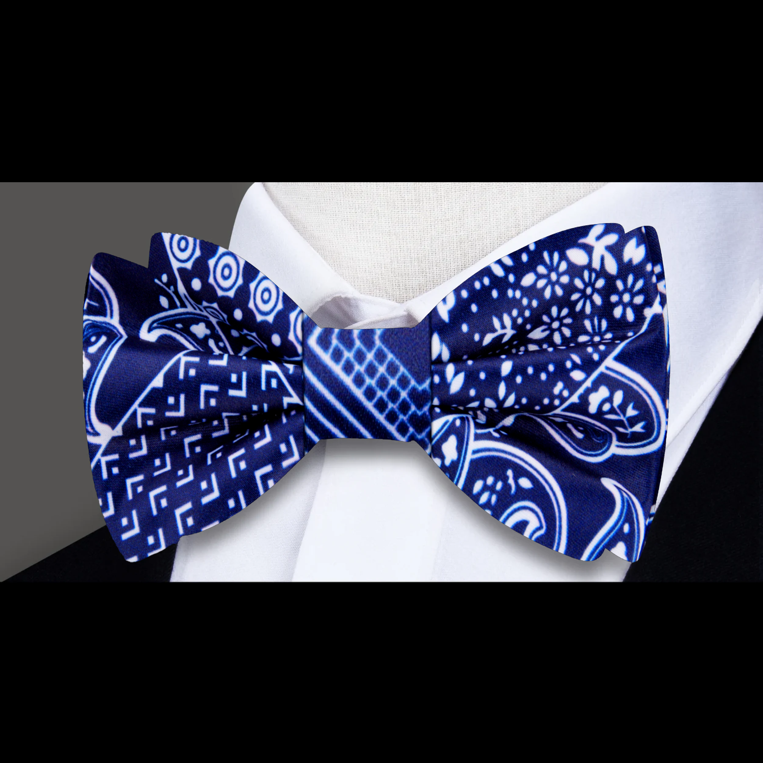 Elegant dark blue paisley bow tie, highlighted against a white background, showcasing its intricate pattern.
