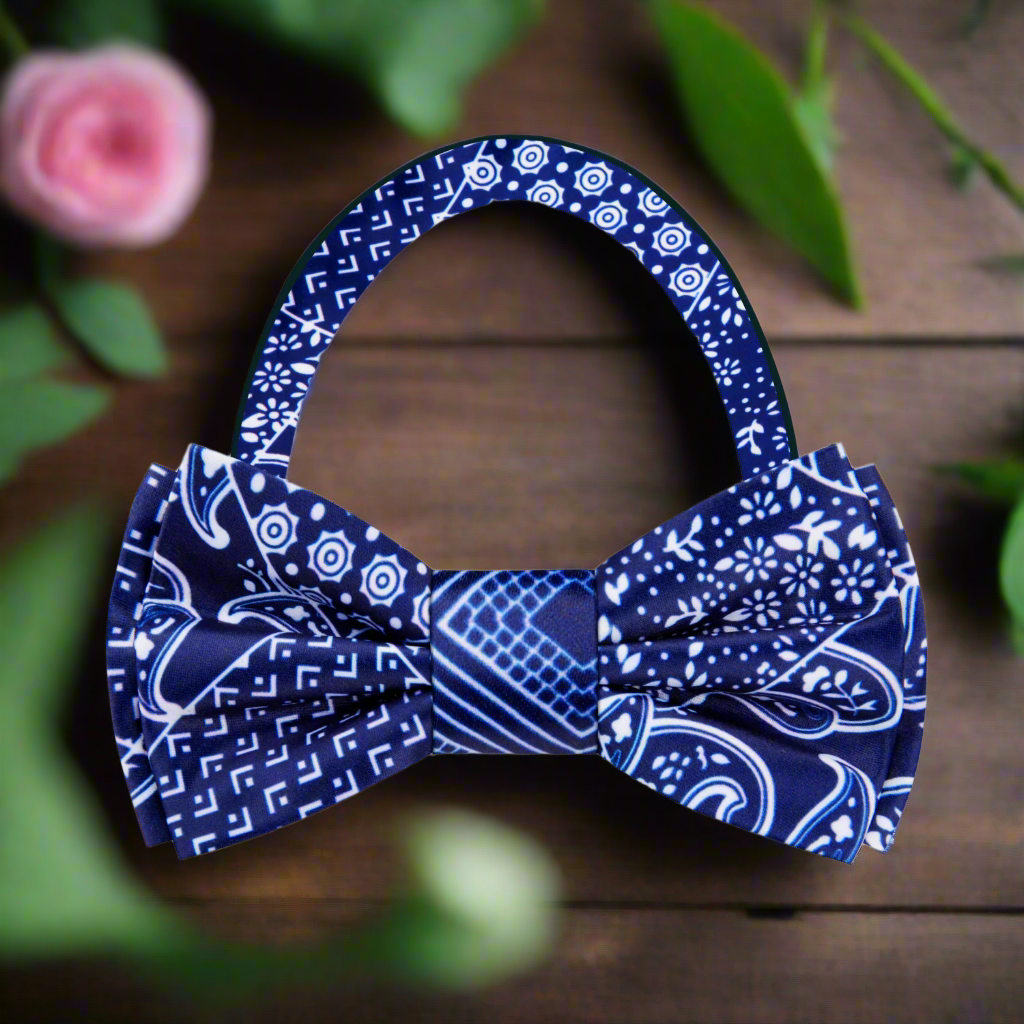 Self-tie paisley bow tie in dark blue and white, styled with a tailored suit for a sophisticated look.