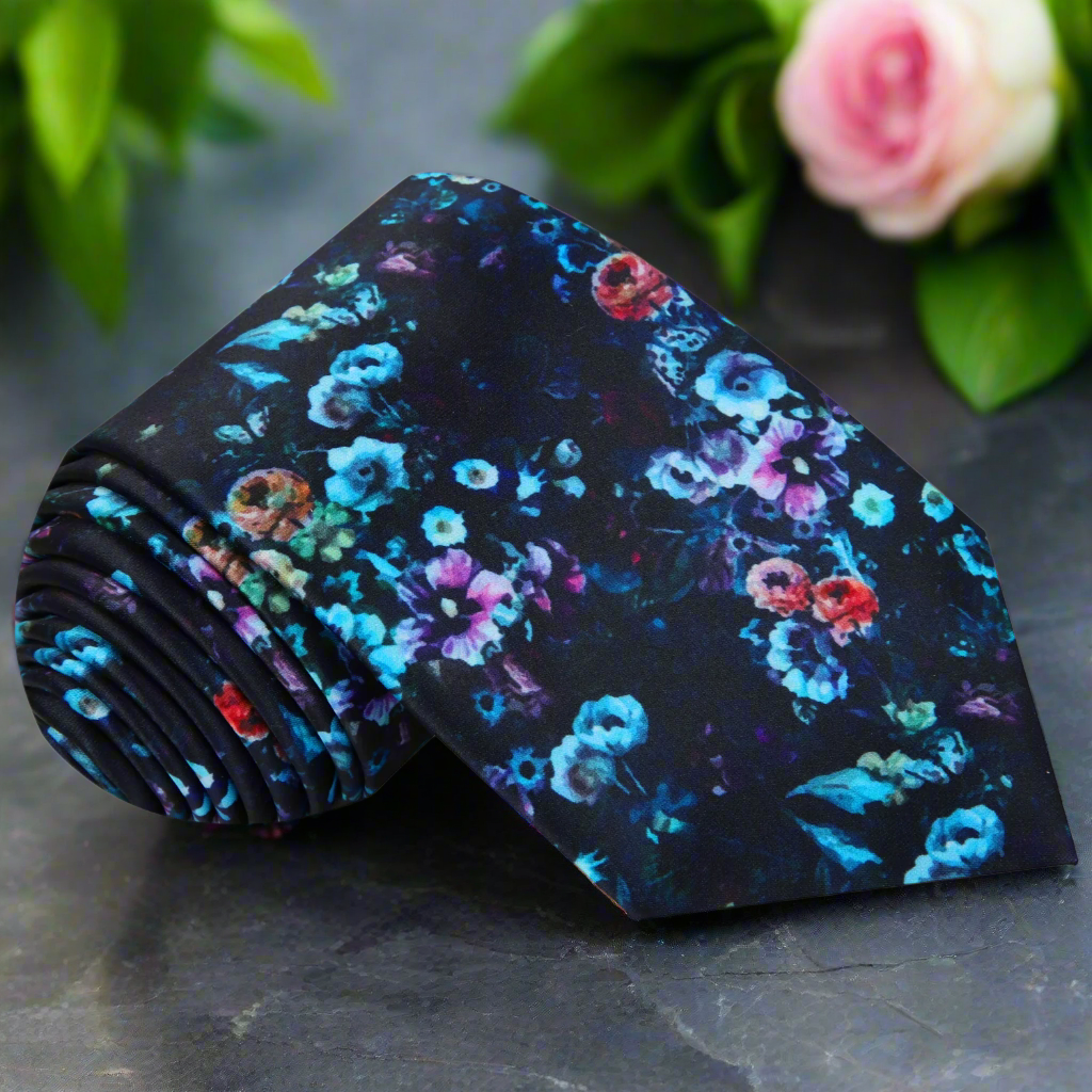 Artistic floral silk tie displayed on a white background, showcasing vibrant colors and intricate floral patterns.