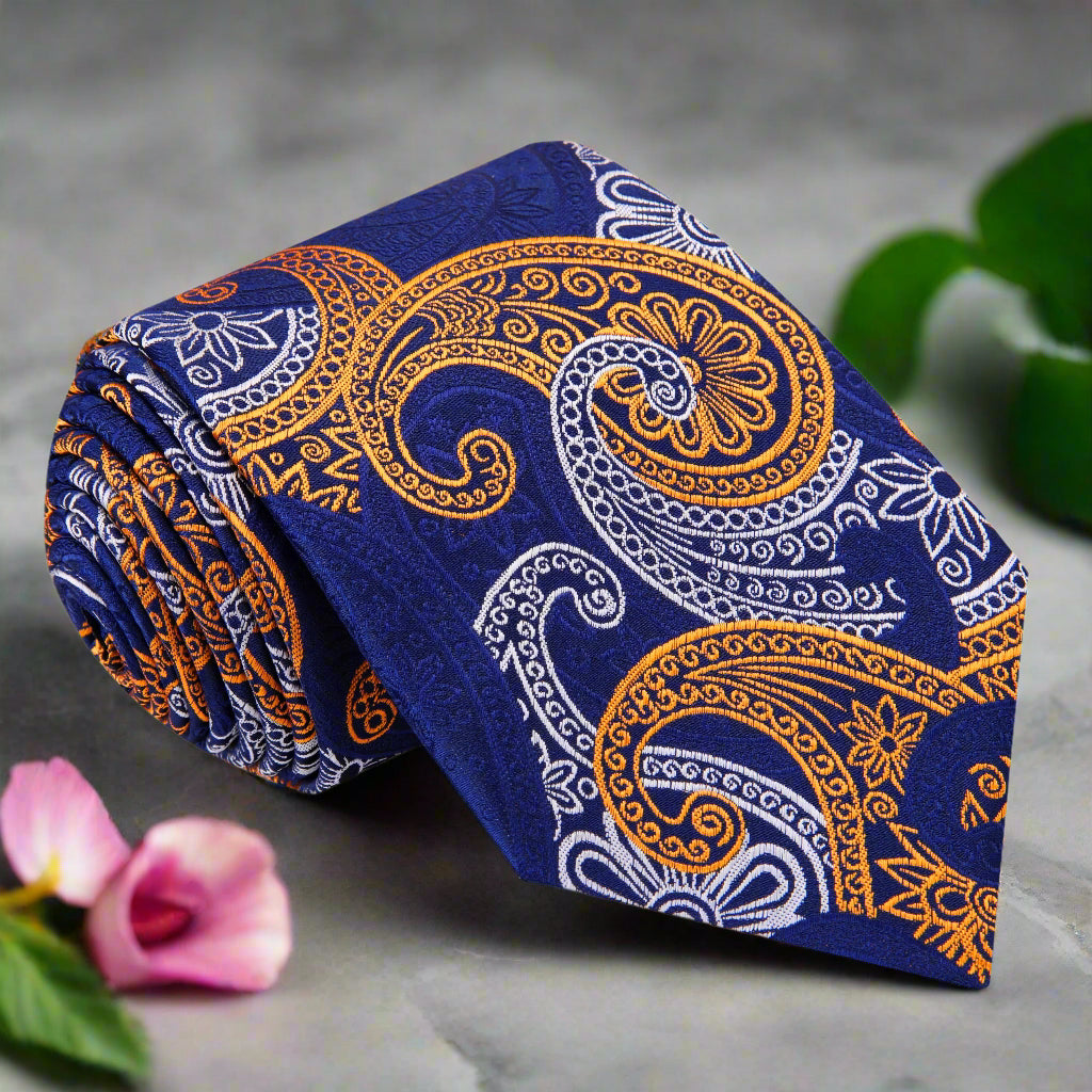 Close-up of a blue silk paisley tie with intricate gold and white pattern, suitable for formal events