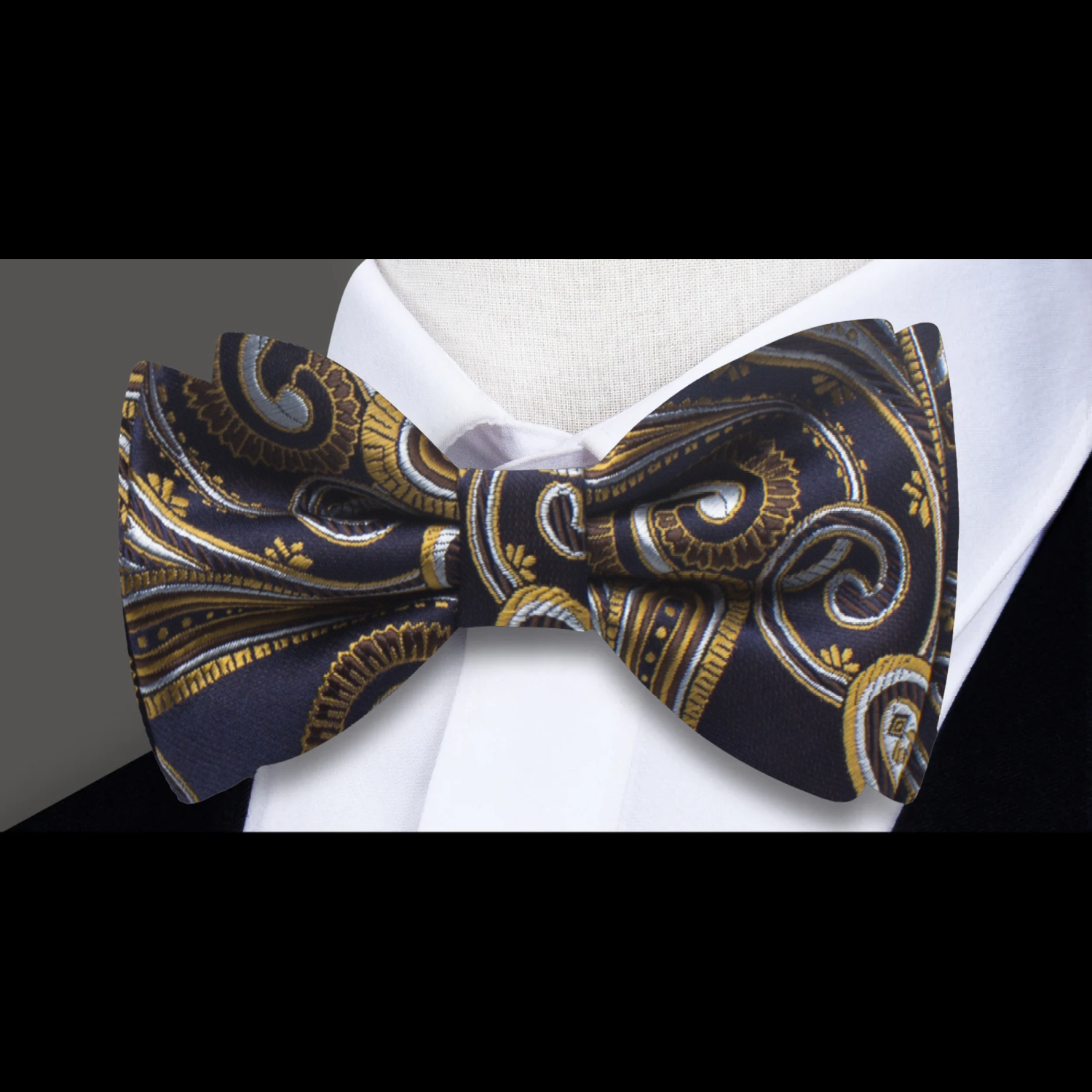 Close-up of the dark blue paisley bow tie showcasing intricate gold patterns.