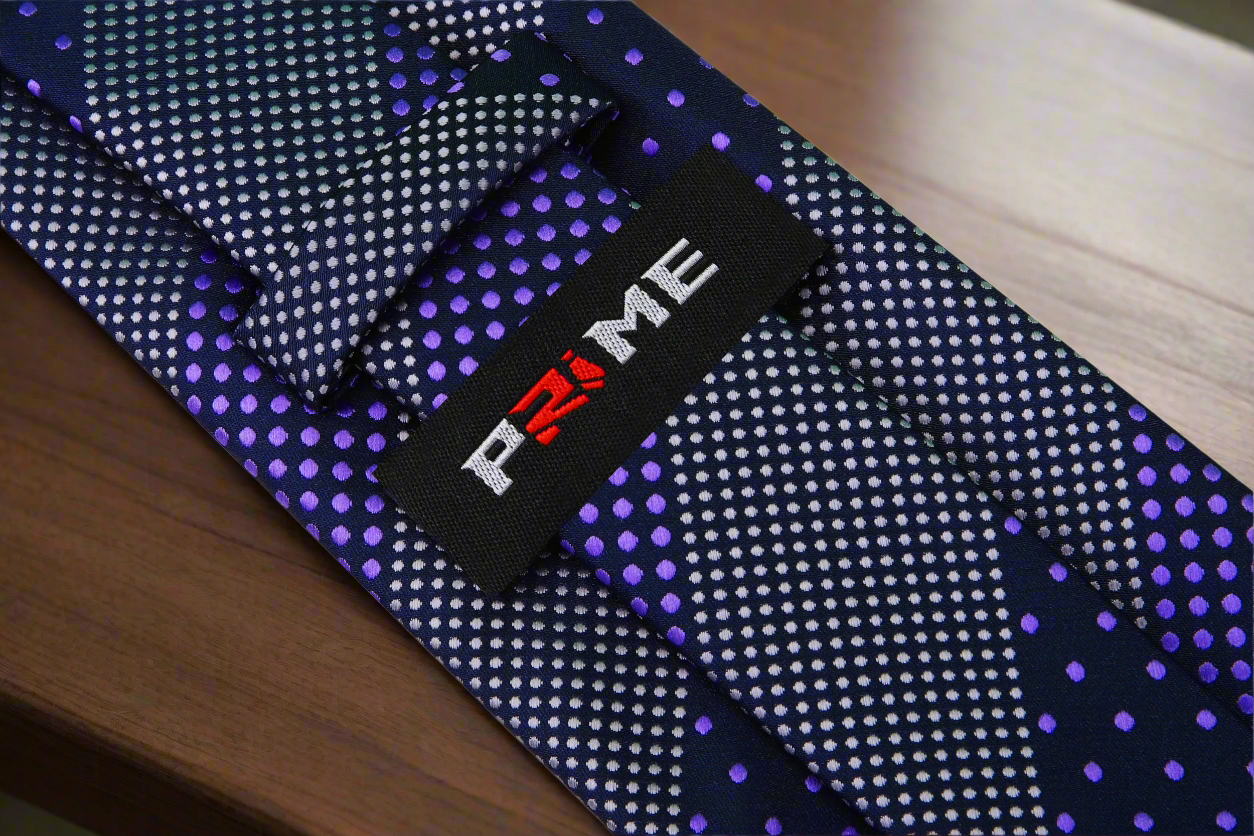 Close-up of the polka dot tie paired with a white dress shirt and charcoal grey suit, highlighting its stylish contrast.