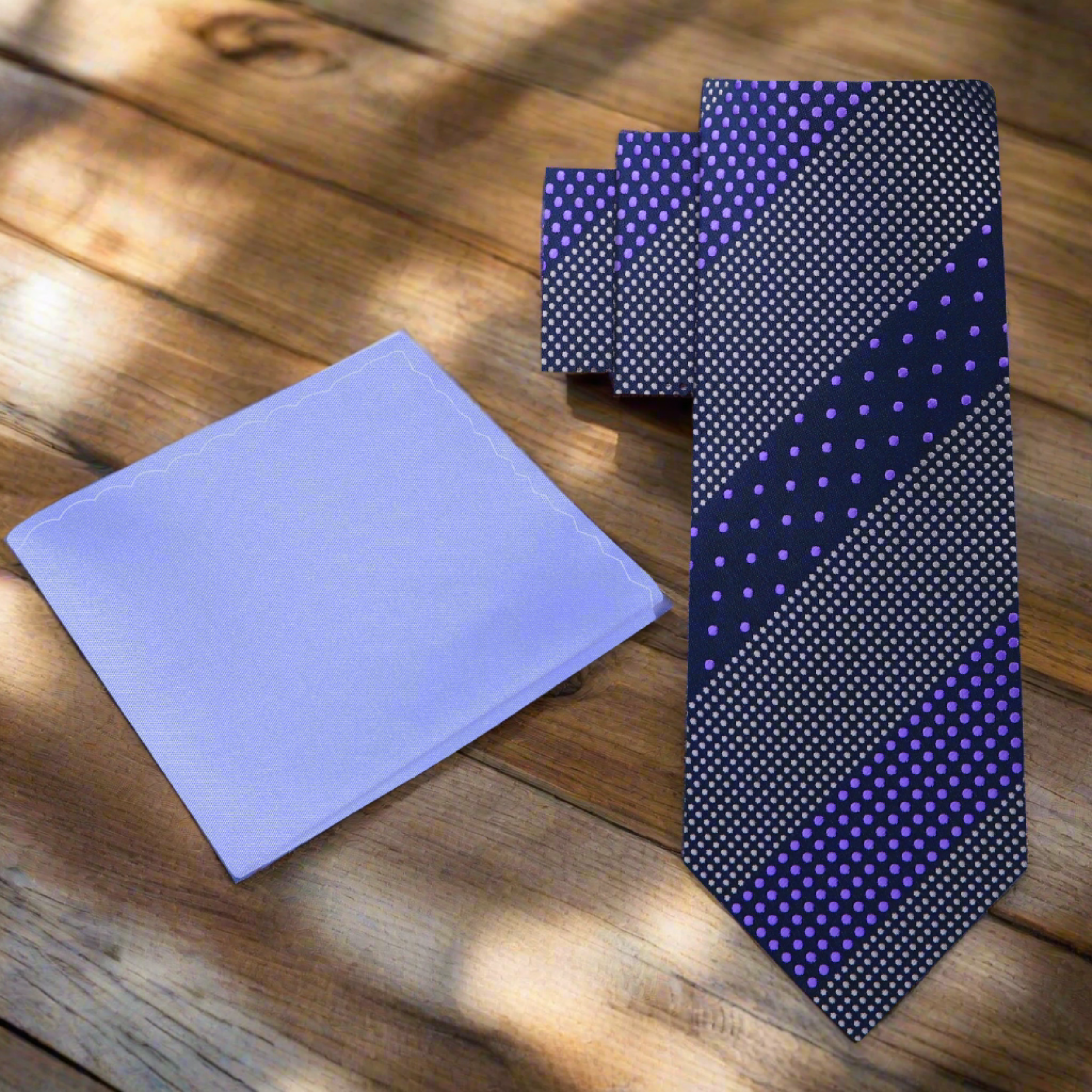 Elegant dark blue polka dot tie with purple accents displayed on a wooden surface, showcasing its sophisticated design.