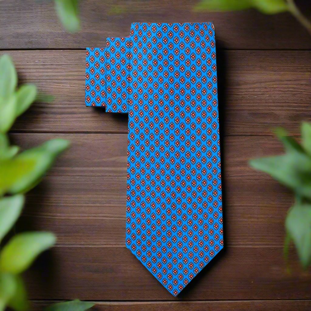 Model wearing the blue silk necktie with red medallions paired with a white dress shirt and navy suit