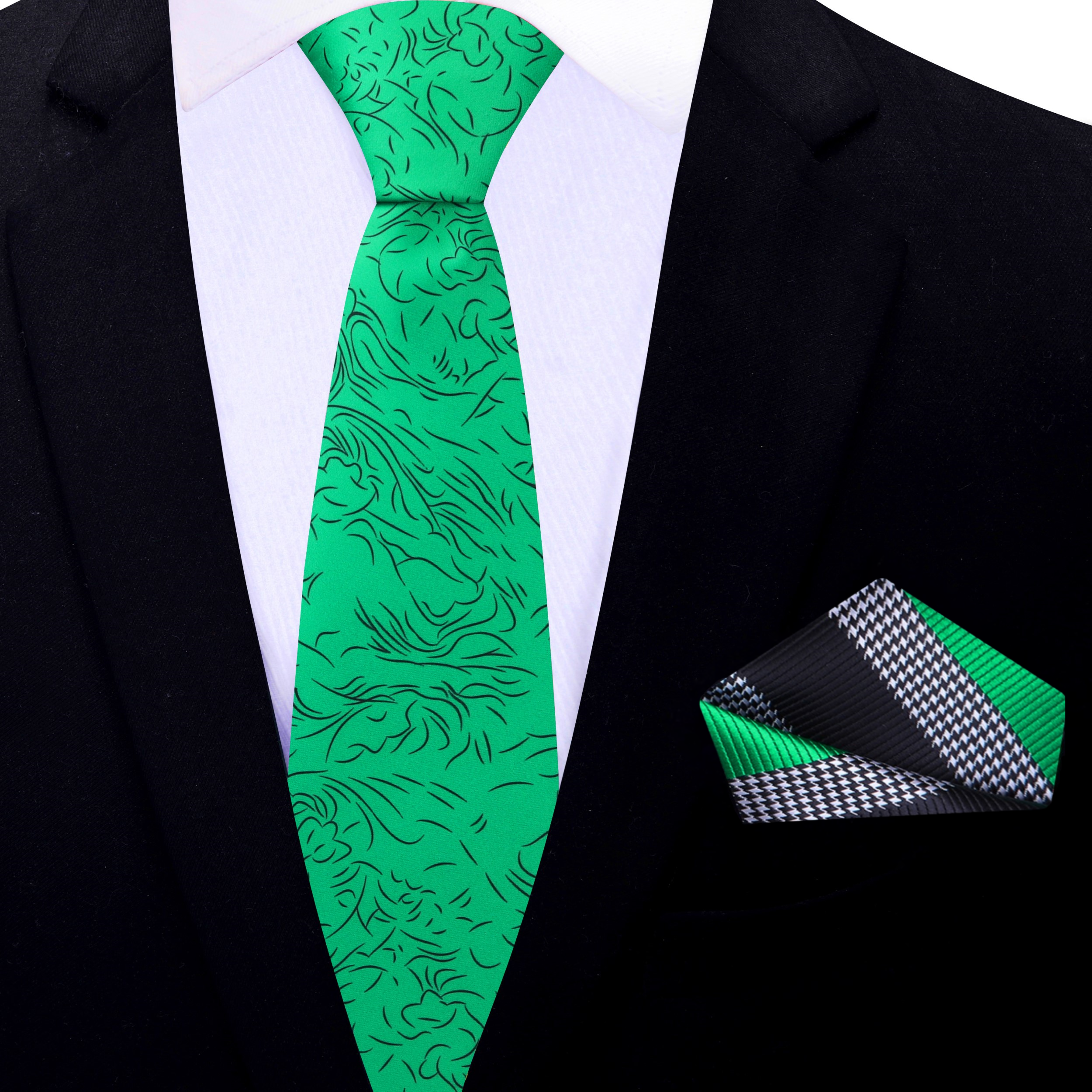 Elegant green silk necktie with black abstract lines draped over a suit jacket
