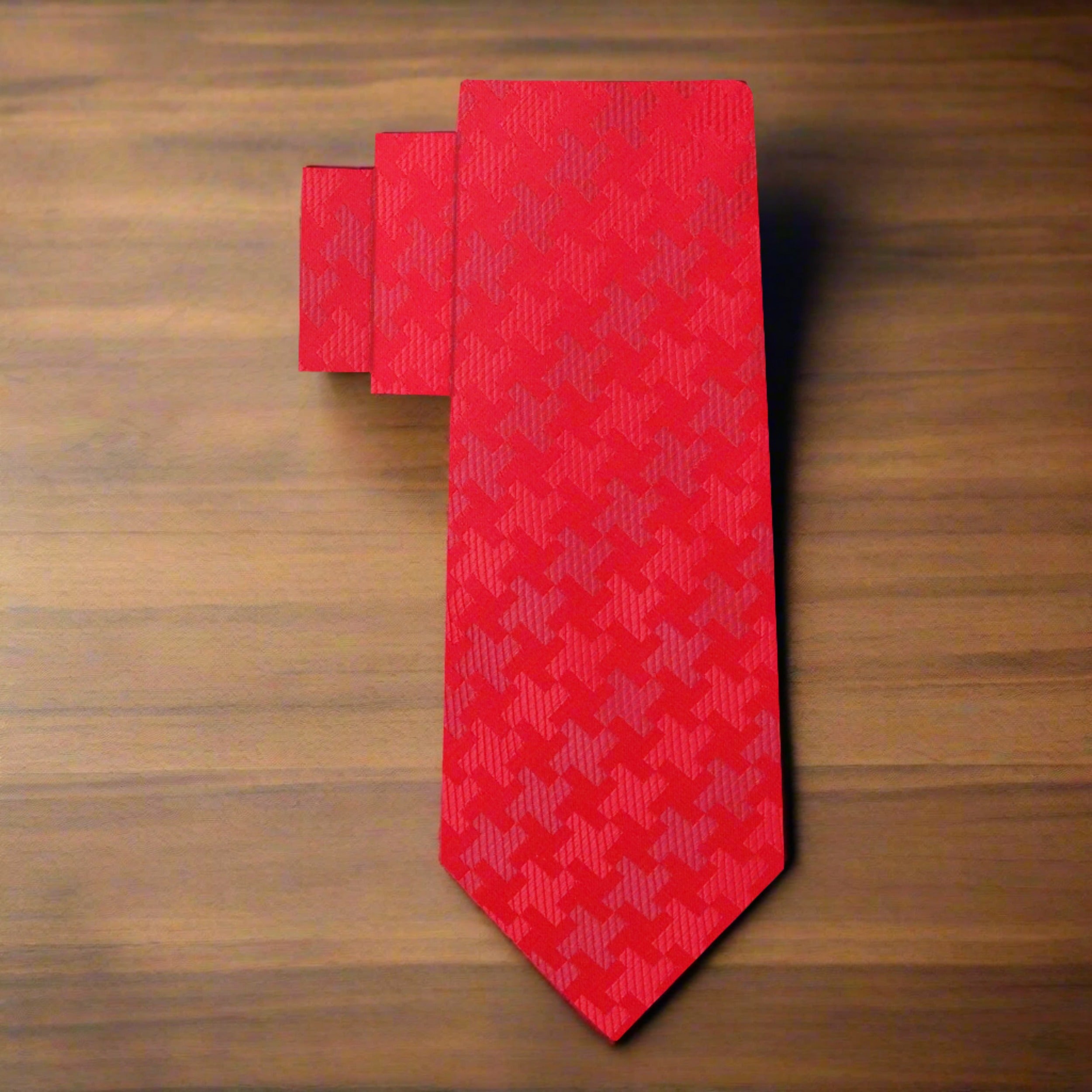 Close-up of the houndstooth pattern on a red silk tie.
