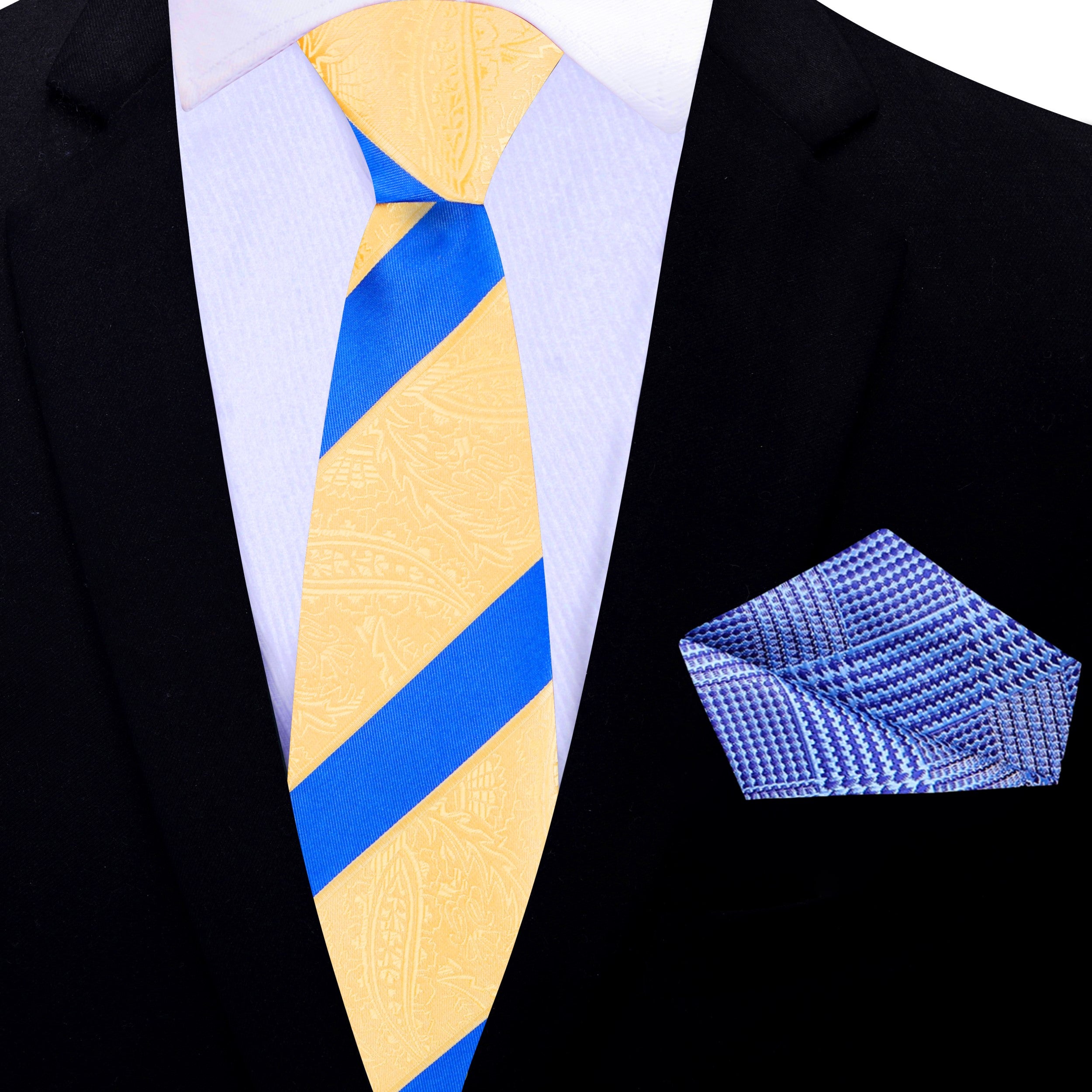 Close-up of the paisley pattern of the yellow necktie against a light blue background.