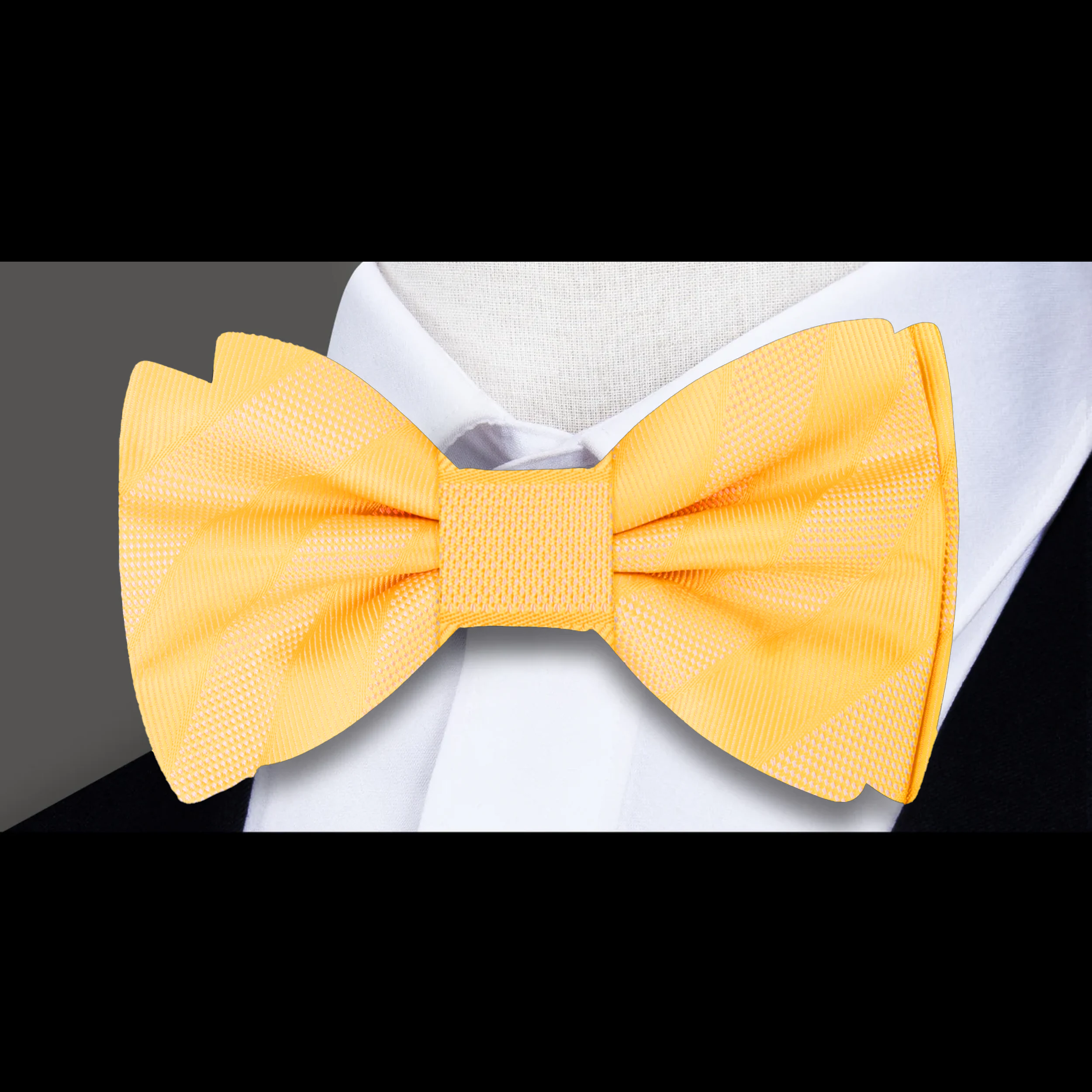 Close-up of the fabric pattern and texture of a yellow gold striped bow tie