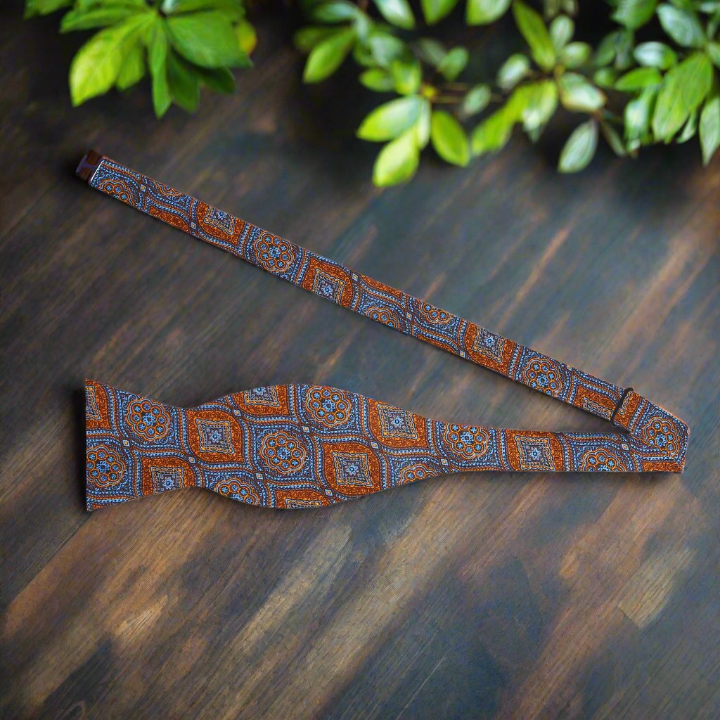Front view of geometric self-tie bow tie in brown, gold, and blue with adjustable strap