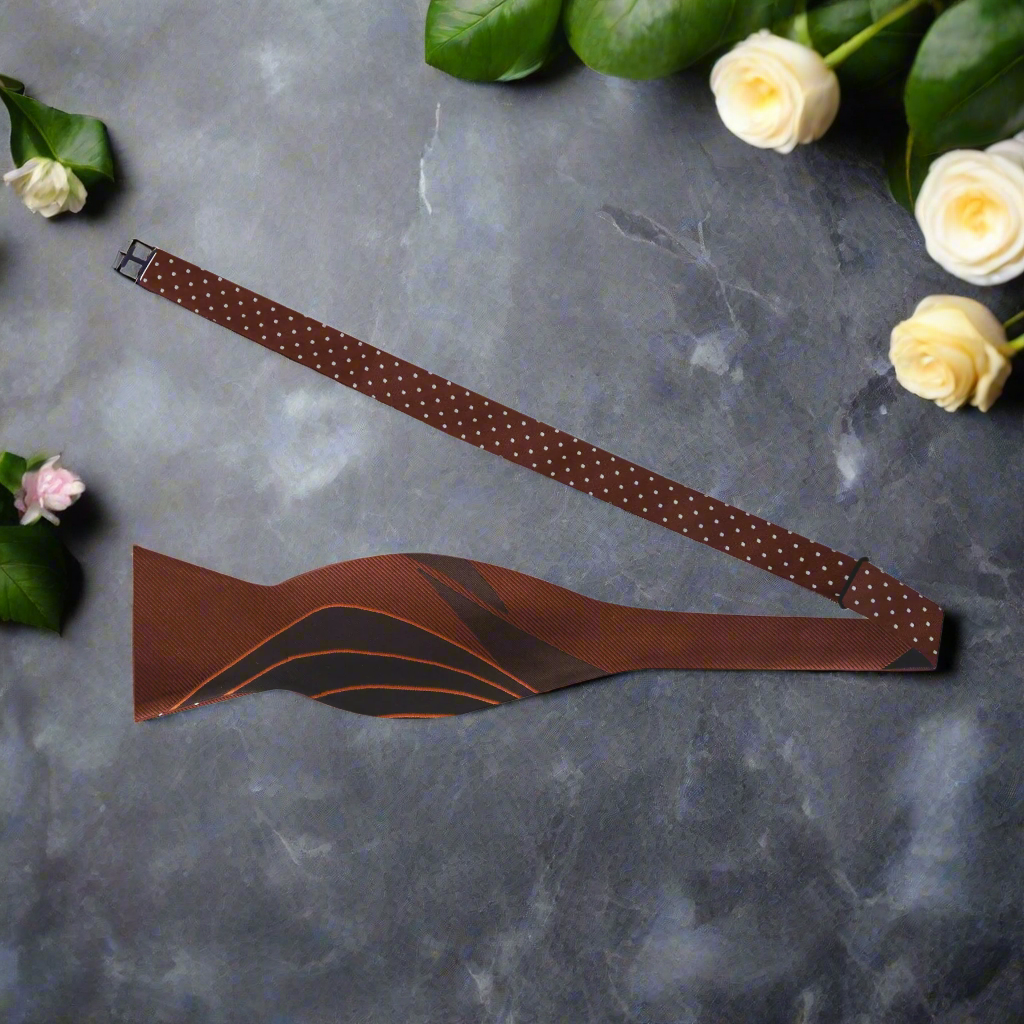 Close-up of reversible silk bow tie with abstract brown pattern, perfect for weddings