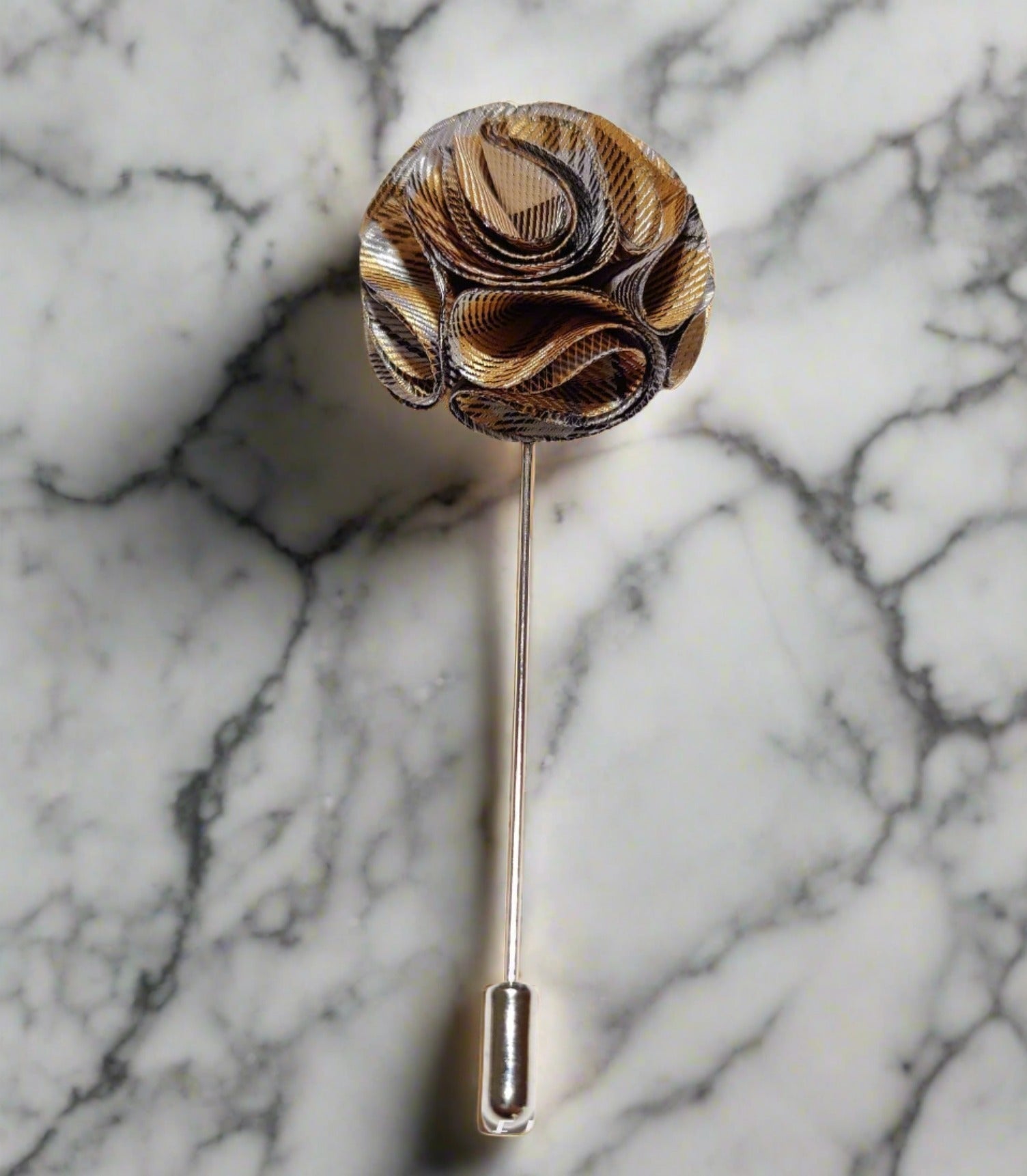 Fabric flower lapel pin on a dark suit, showing detailed petals and secure fastening