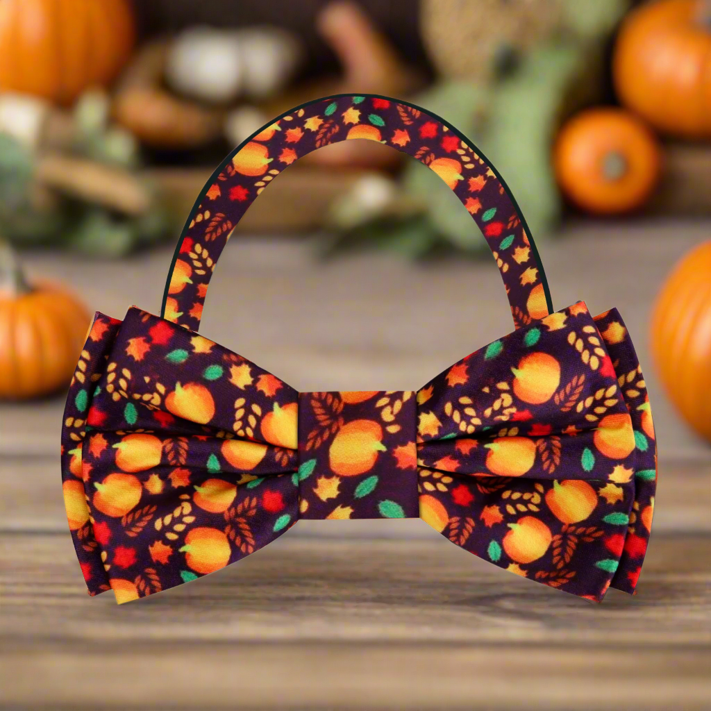 Close-up of fall leaves and pumpkin silk bow tie on a model for autumn wedding attire