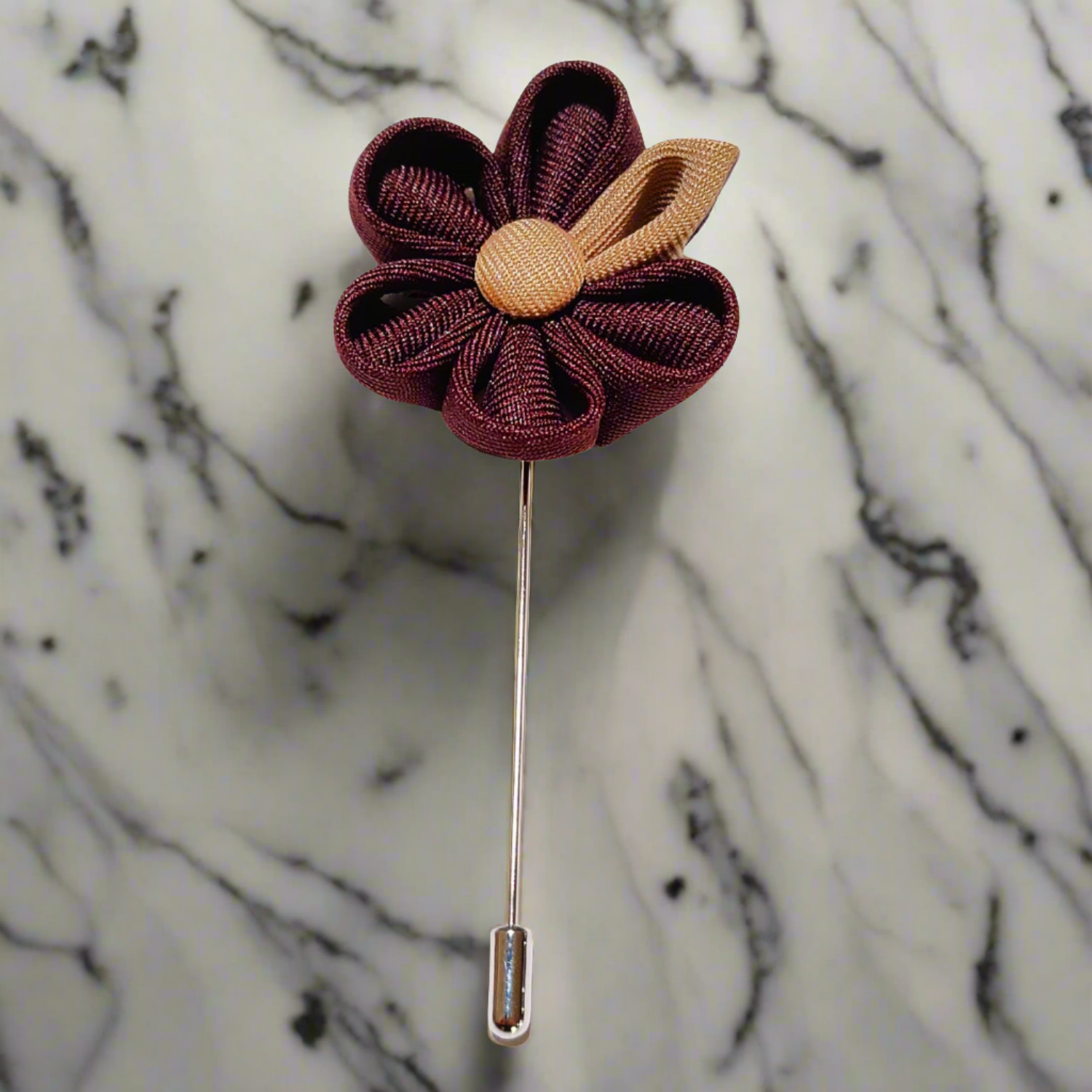Close-up of brown and tan flower lapel pin on a navy suit jacket – showcasing the texture and petal details