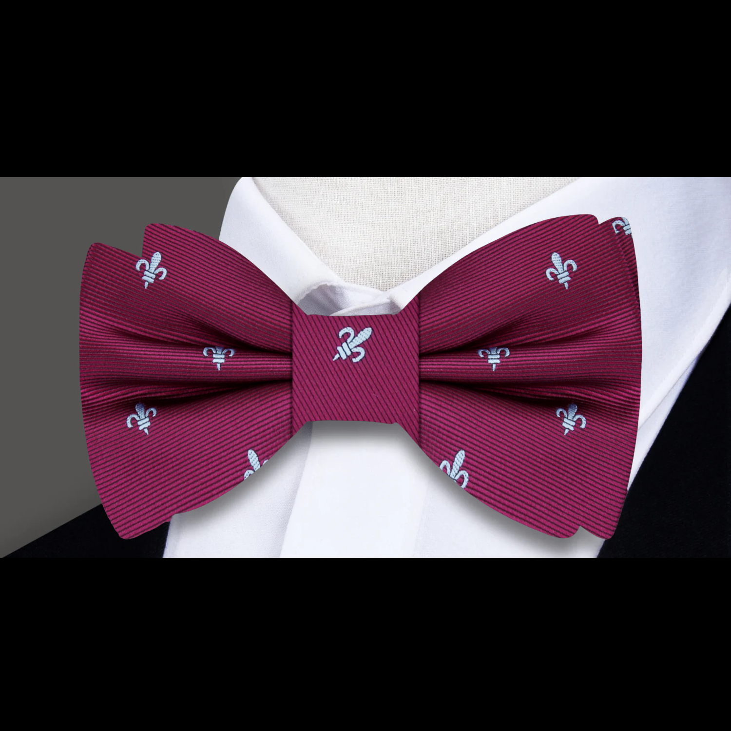 Elegant silk bow tie with fleur de lis pattern on a white dress shirt