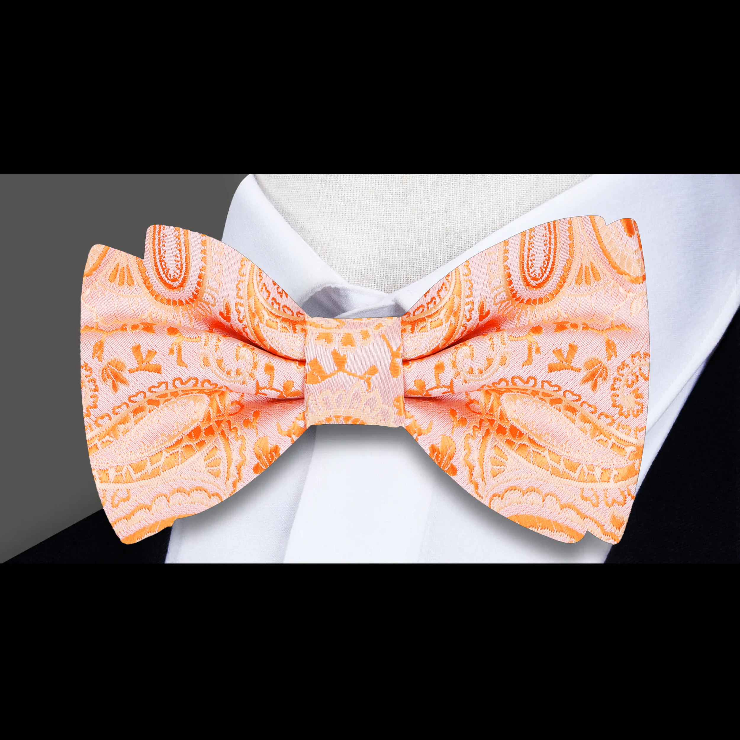 Close-up of the intricate paisley pattern on the orange silk bow tie