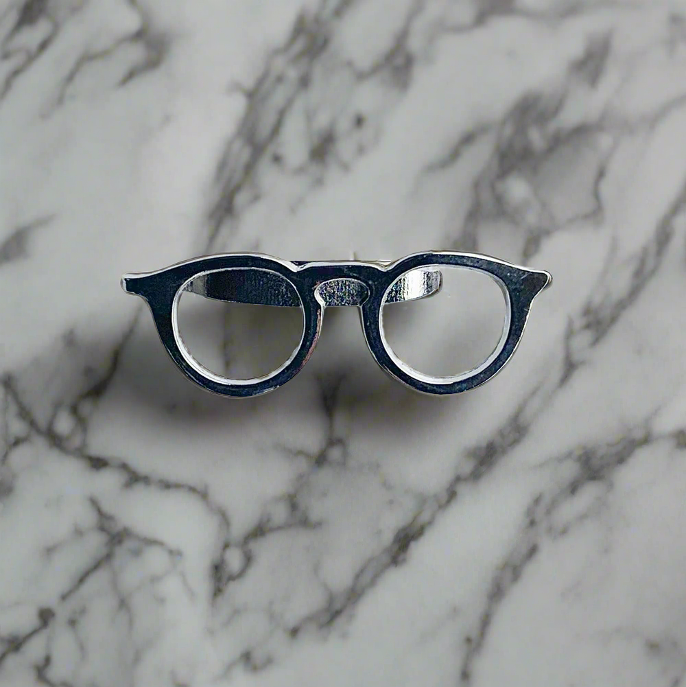 Close-up of a glasses tie clip attached to a white dress shirt for formal wear