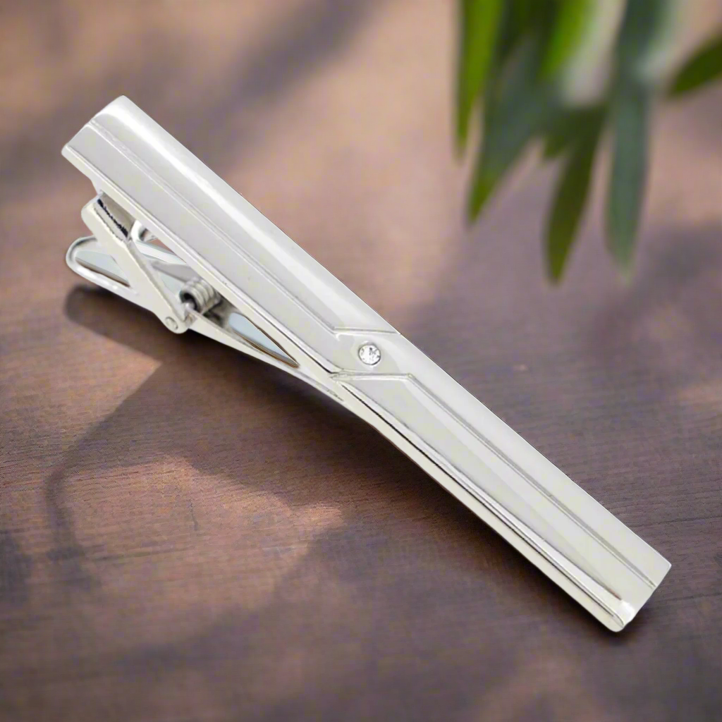 Front view of a sleek chrome tie clip on a dress shirt