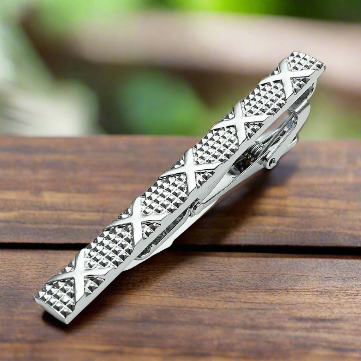 Elegant tie bar in mahogany with chrome floral design, perfect for formal occasions.