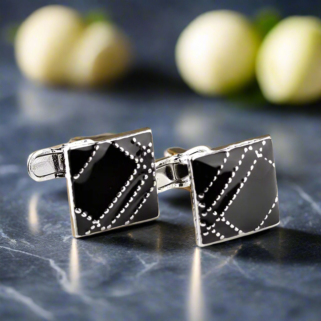Luxury chrome cufflinks with red stone, angled view
