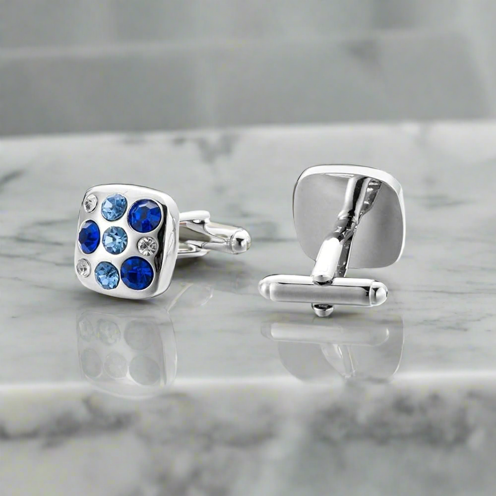 Stylish blue cufflinks with teal accents on a suit sleeve