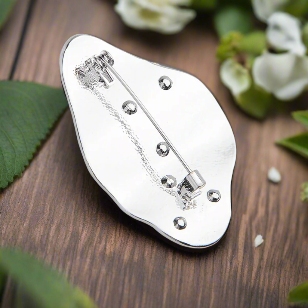 Close-up view of the Abstract Face Lapel Pin showcasing its intricate design and shiny finish.