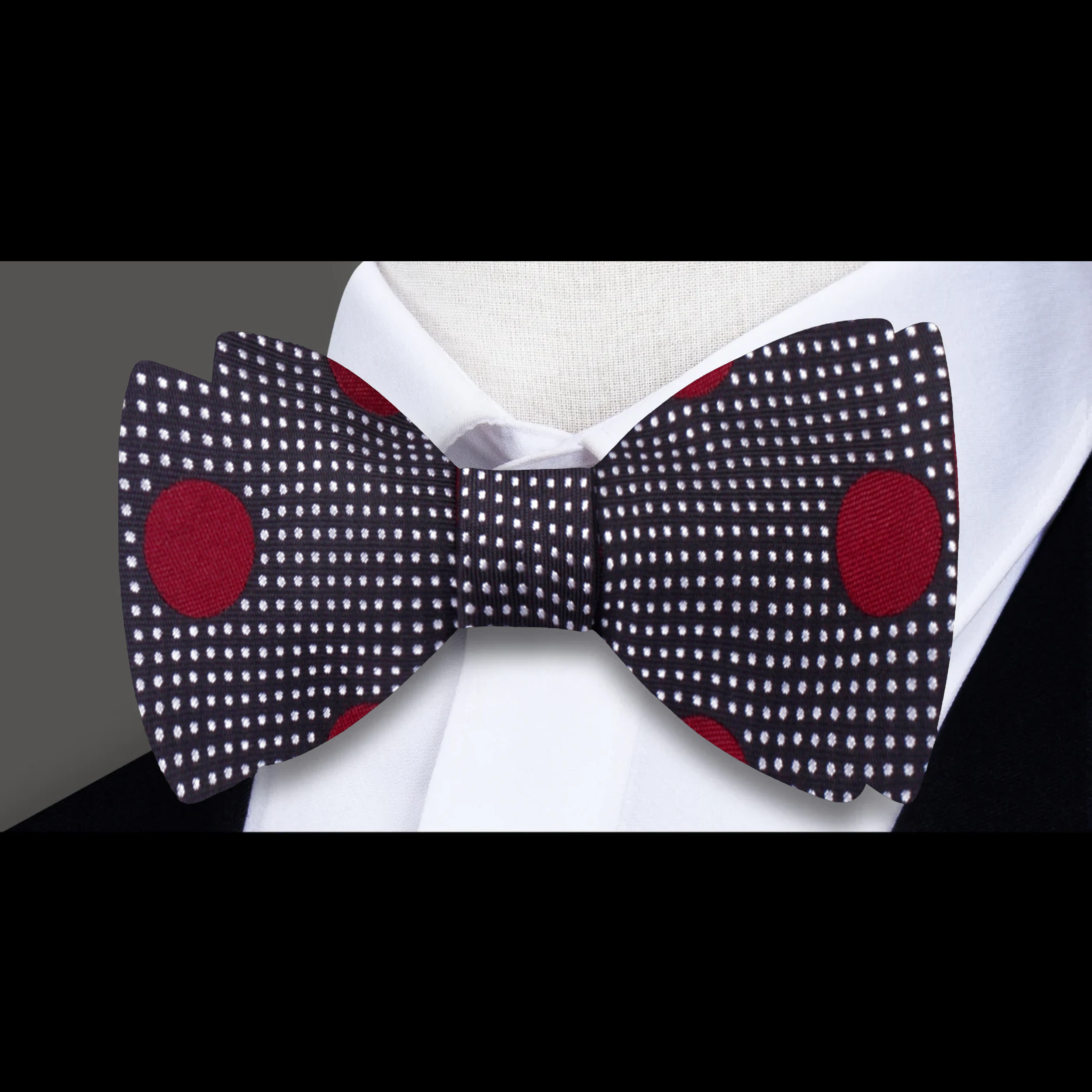 Elegant dark blue bow tie with burgundy dots on a white shirt for formal occasions