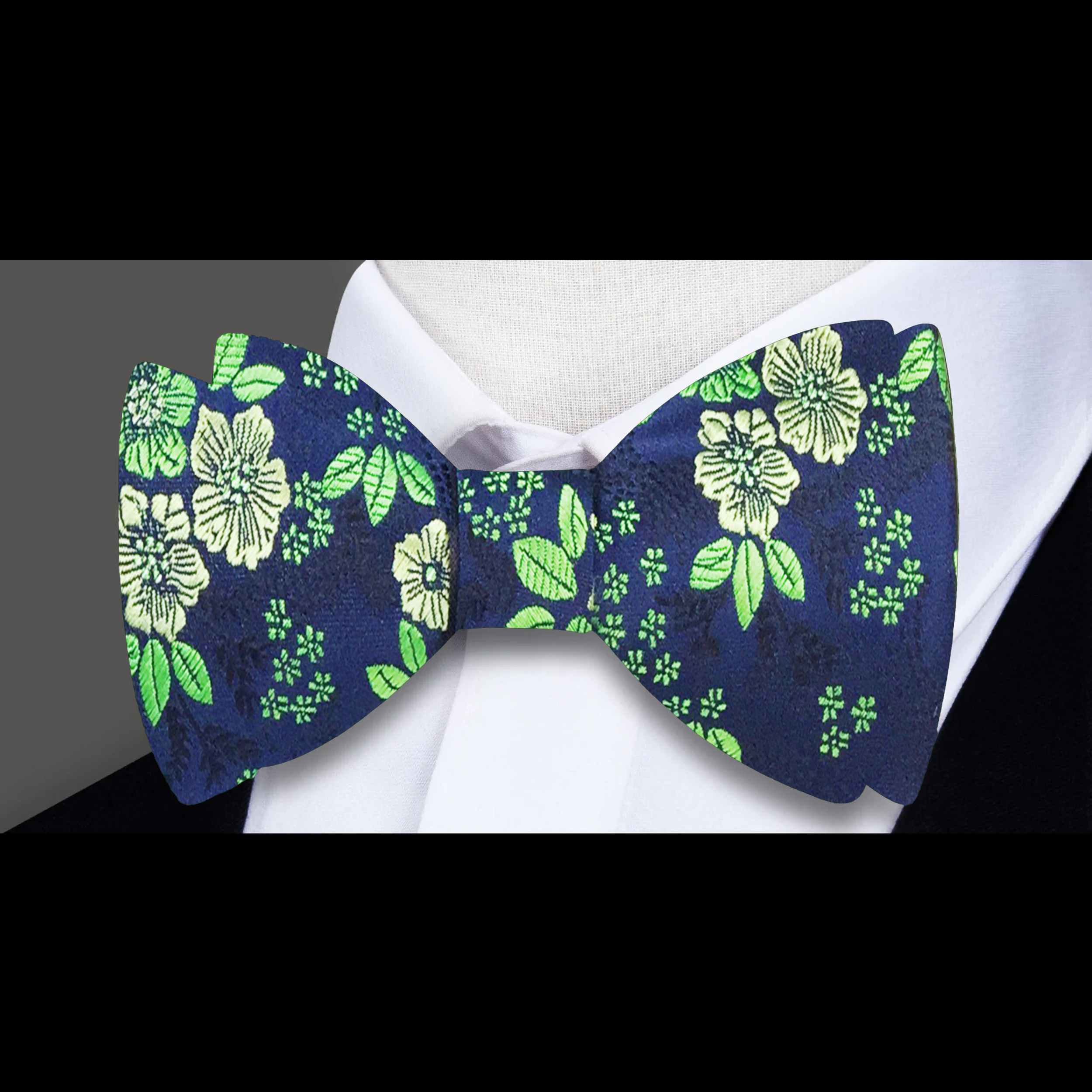 Close-up of a mens floral bow tie featuring intricate flower patterns in vibrant colors.