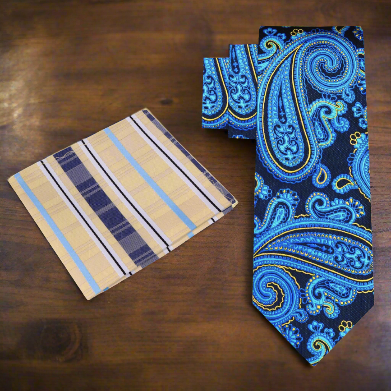Model wearing a blue paisley silk necktie paired with a light grey suit, exemplifying modern style.