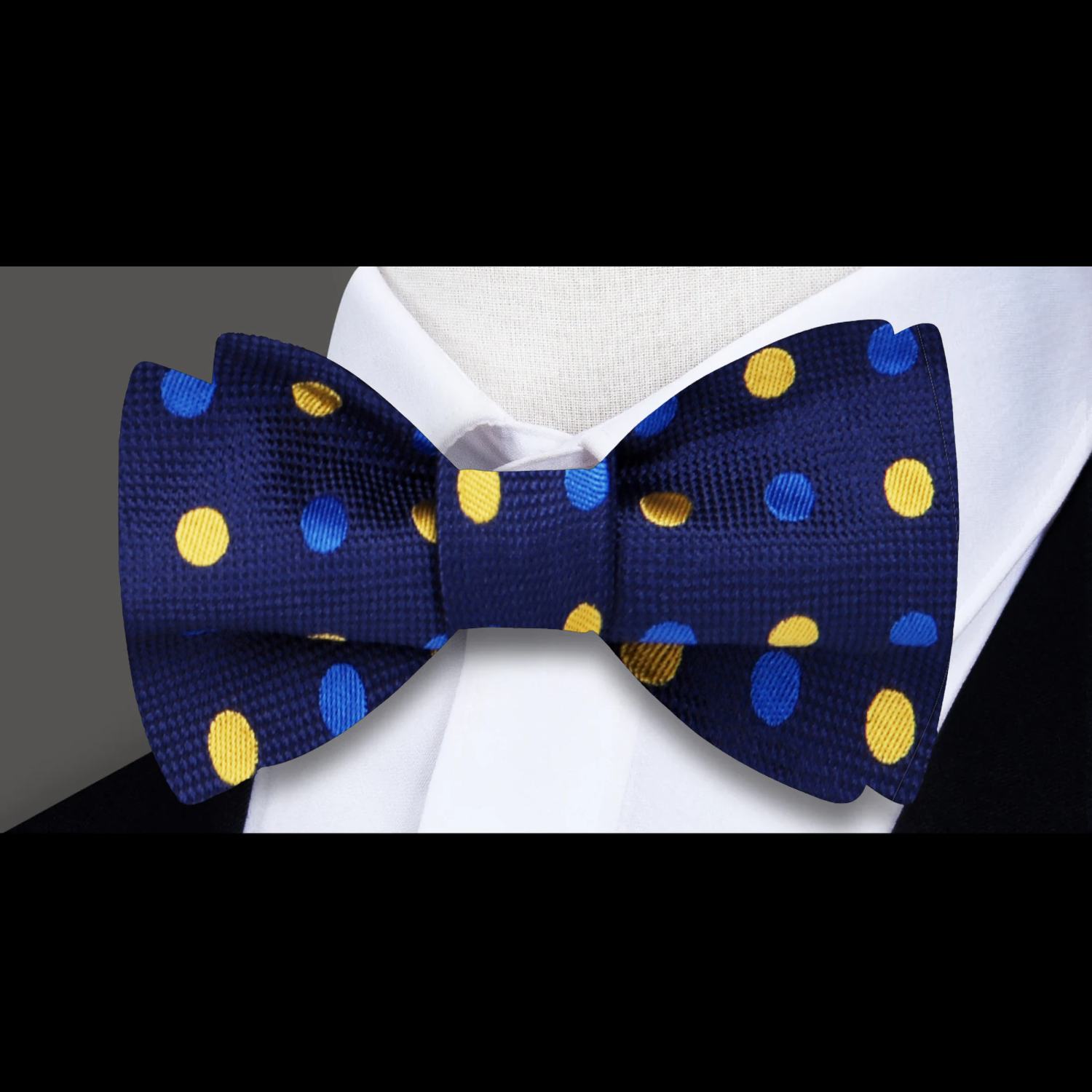 Elegant setup featuring the bow tie with a matching pocket square against a navy suit.