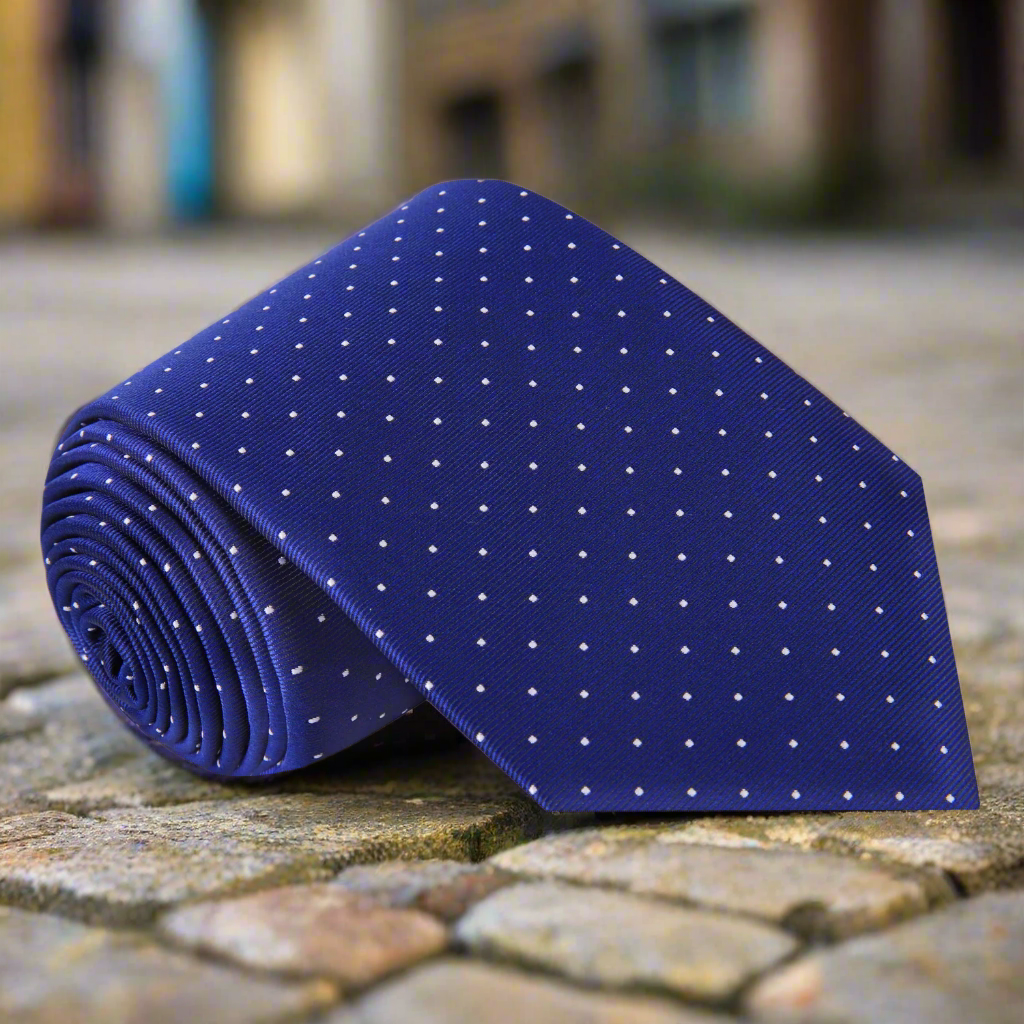 Front view of blue silk tie with white dots worn with navy suit – elegant for weddings and meetings