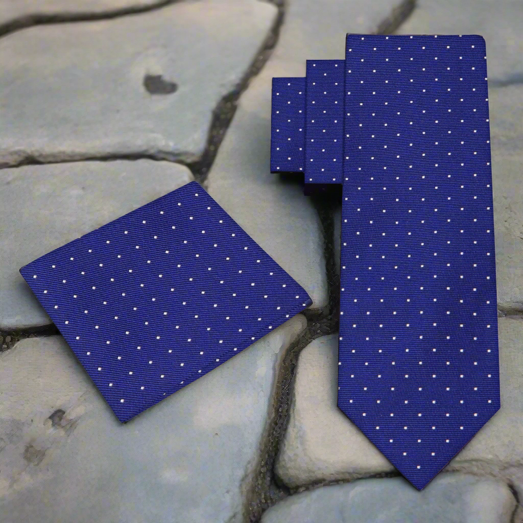 Close-up of silk necktie fabric showing white dotted pattern and 2.5” width