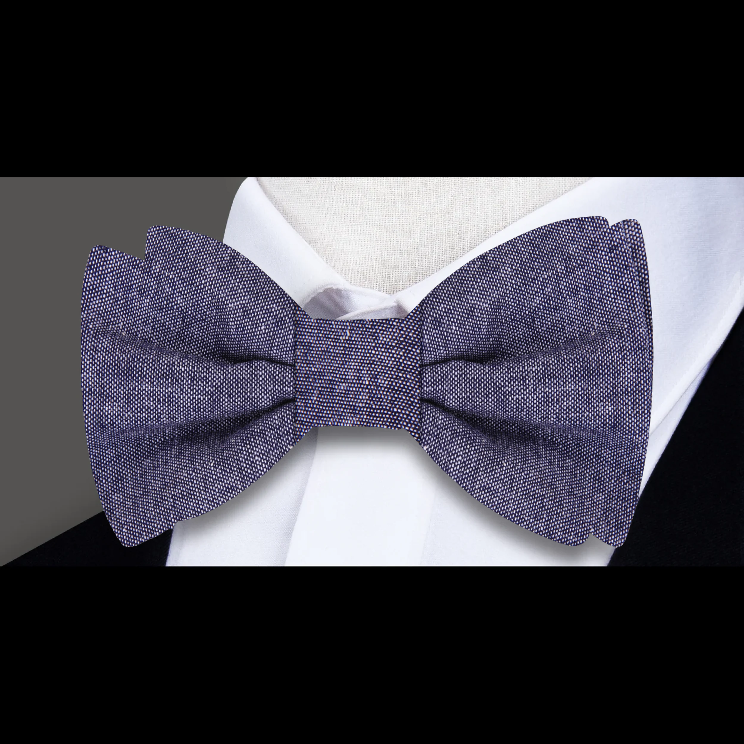 Groom wearing a navy linen bow tie with pocket square at a wedding reception