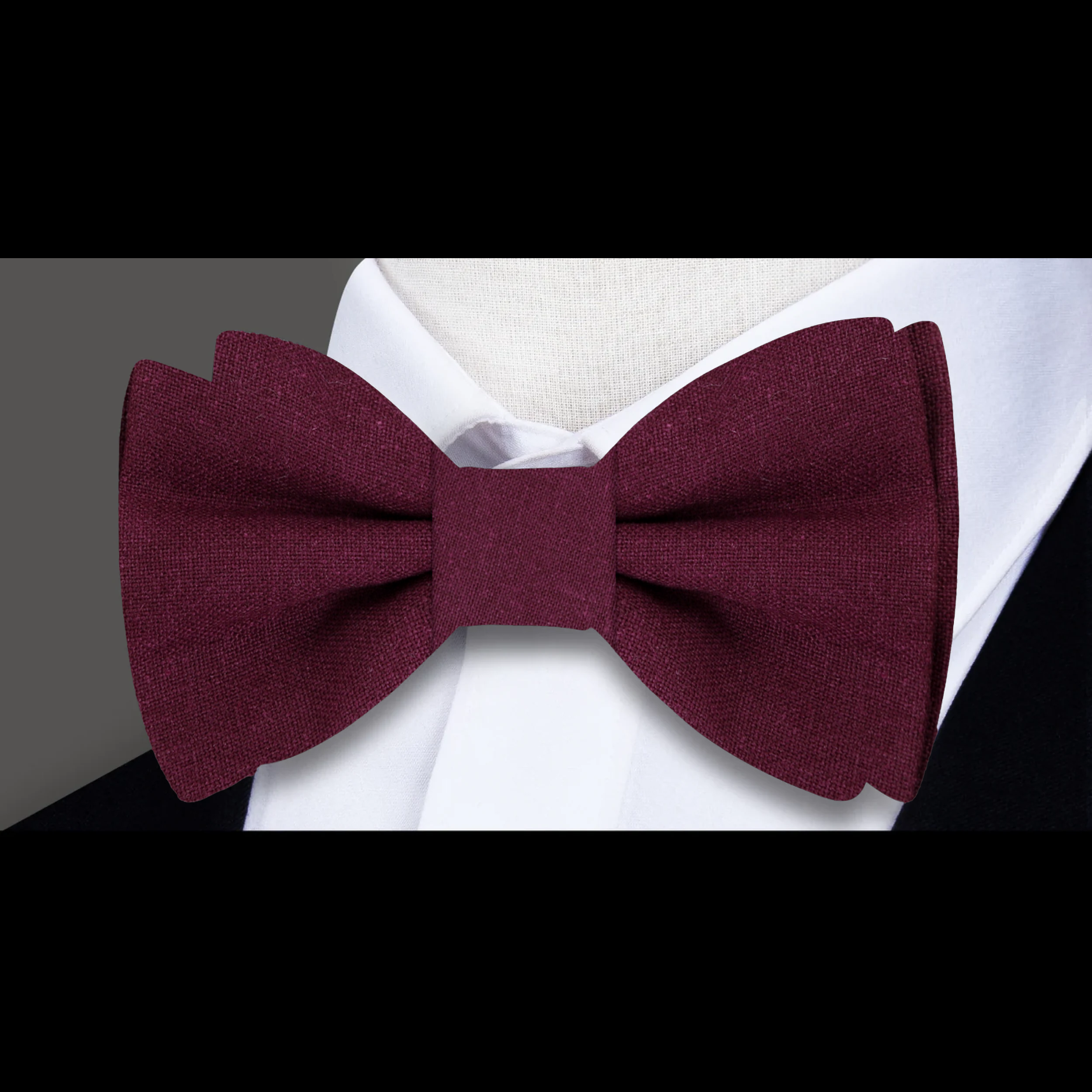 Groom wearing a navy linen bow tie with pocket square at a wedding reception