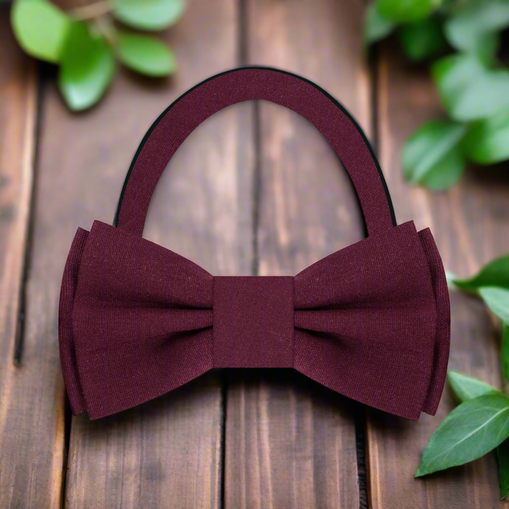 Fashionable man adjusting a deep red linen bow tie, showcasing effortless elegance