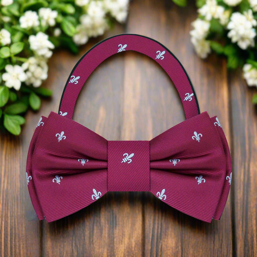 Close-up of a pre-tied deep red fleur de lis bow tie for wedding attire