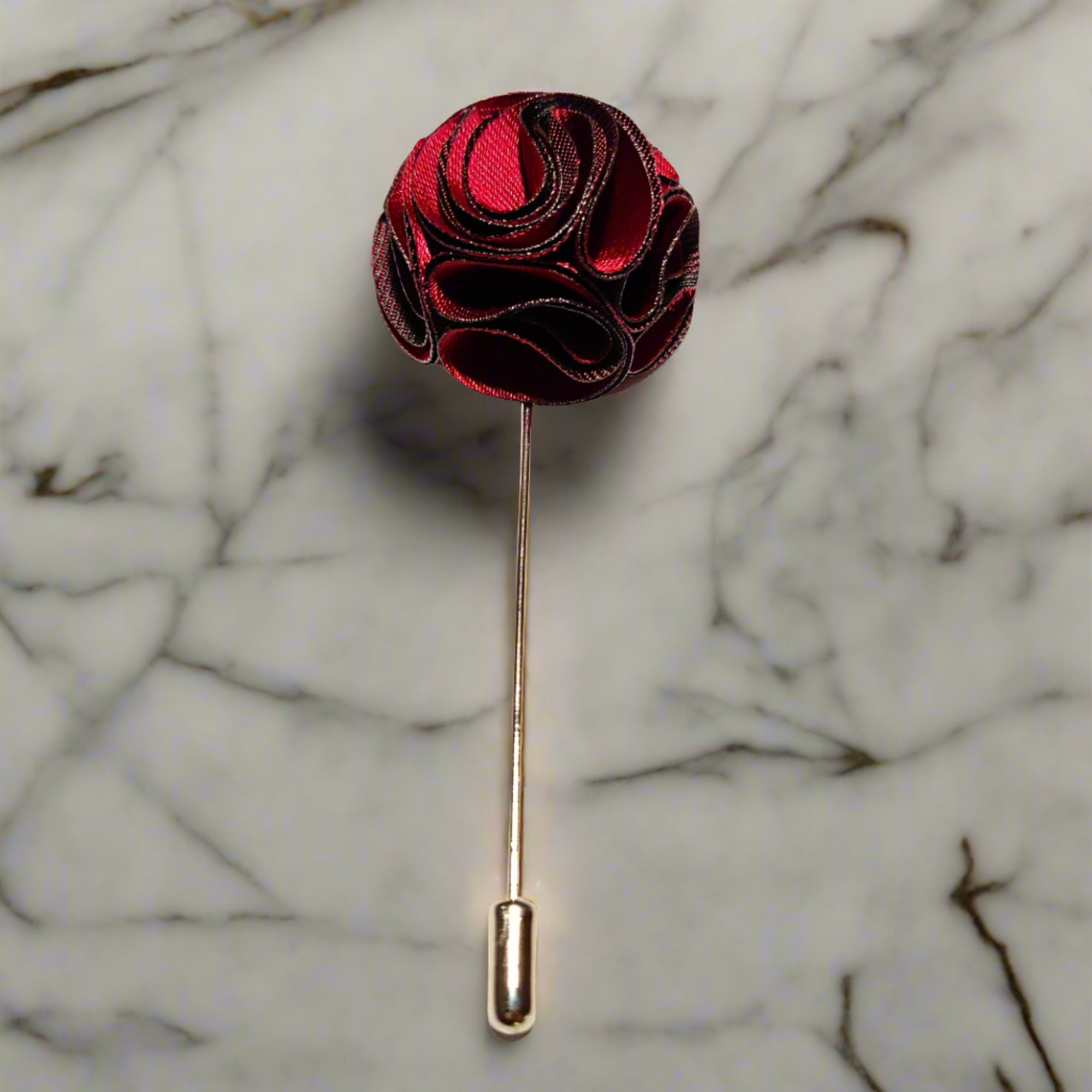 Fabric flower lapel pin on a dark suit, showing detailed petals and secure fastening