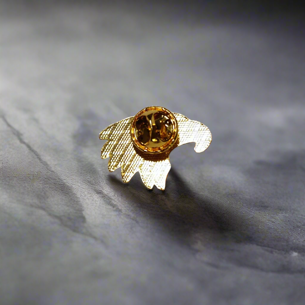 Close-up of eagle lapel pin with red, white, and blue design on a dress shirt