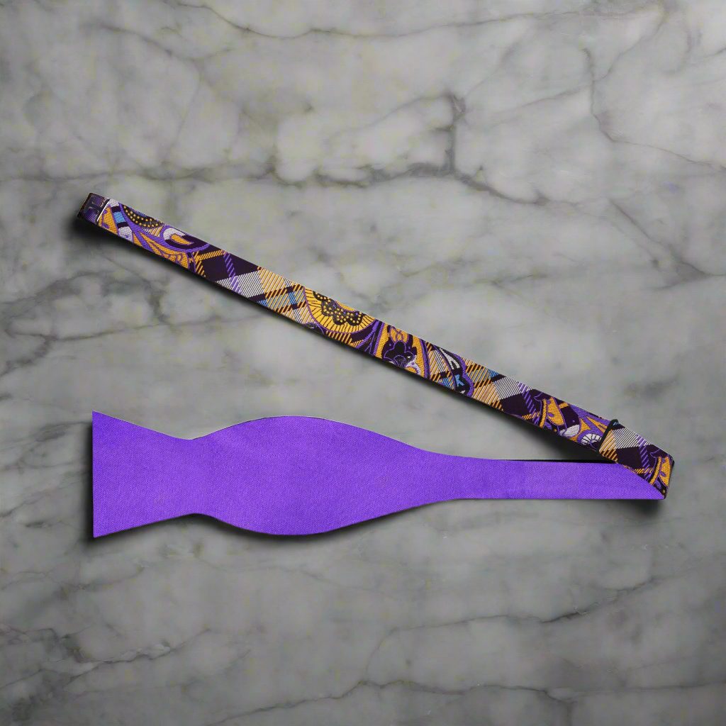 Close-up of dual-tone silk self-tie bow tie in purple and gold, styled with a white dress shirt
