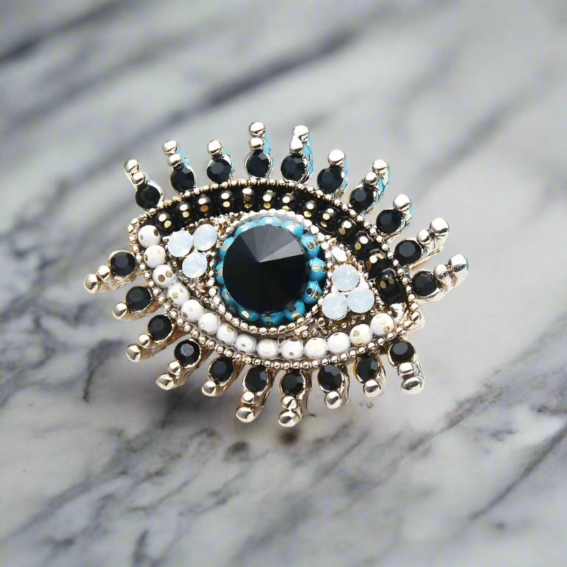 Black stone variant of the eye lapel pin showcased against a white dress shirt.