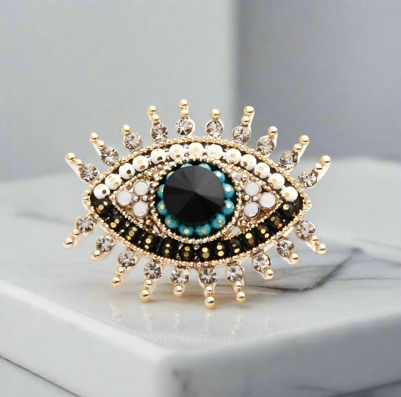 Black stone variant of the eye lapel pin showcased against a white dress shirt.