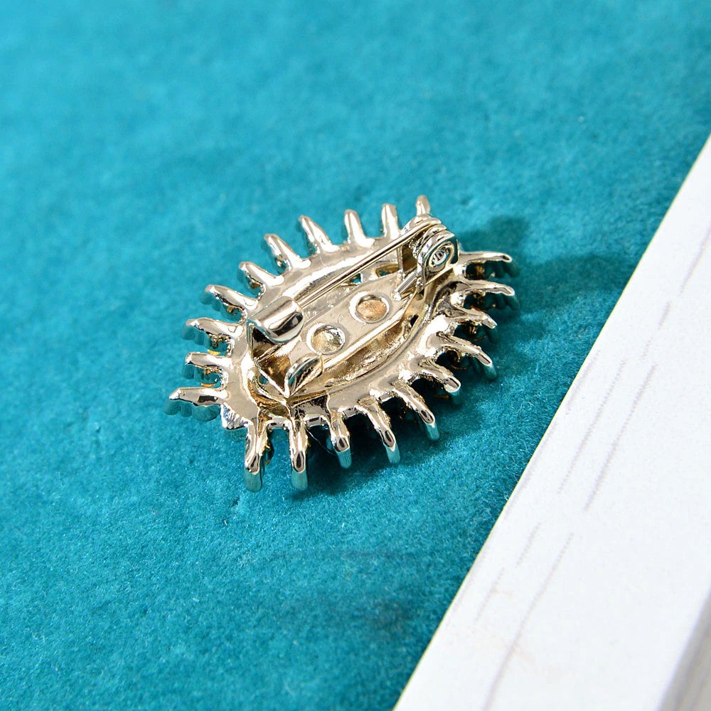 The eye lapel pin styled on a deep blue suit, highlighting its elegant design.