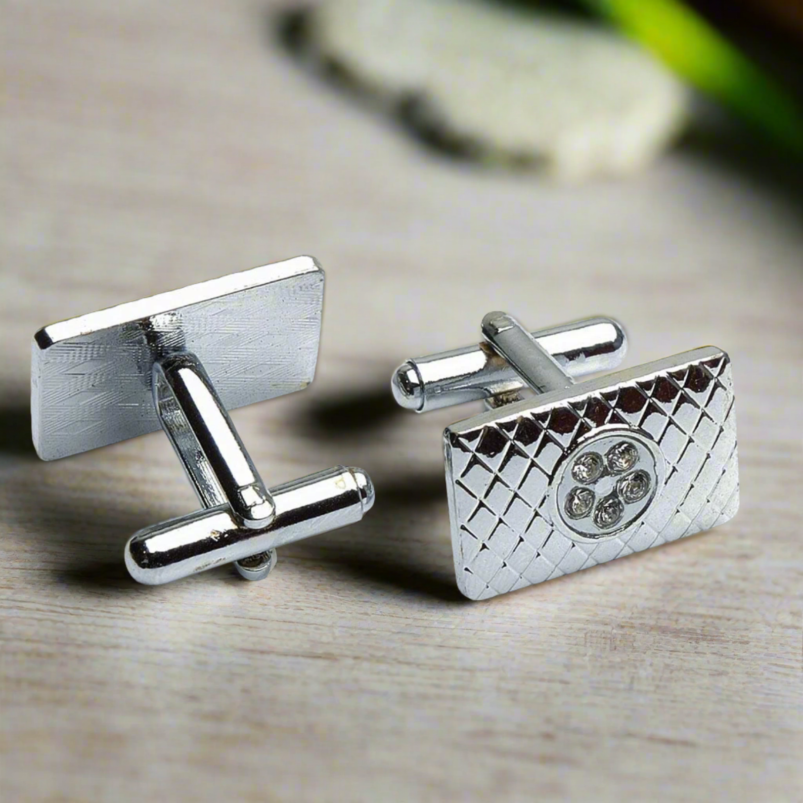 Designer cufflinks placed next to formal black tie attire on display