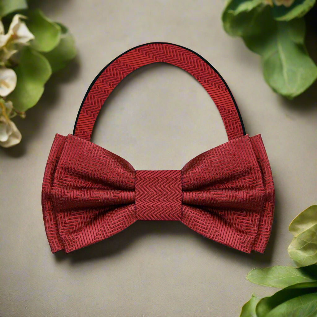 Close-up of the garnet red silk bow tie showing its luxurious fabric and solid lined texture.